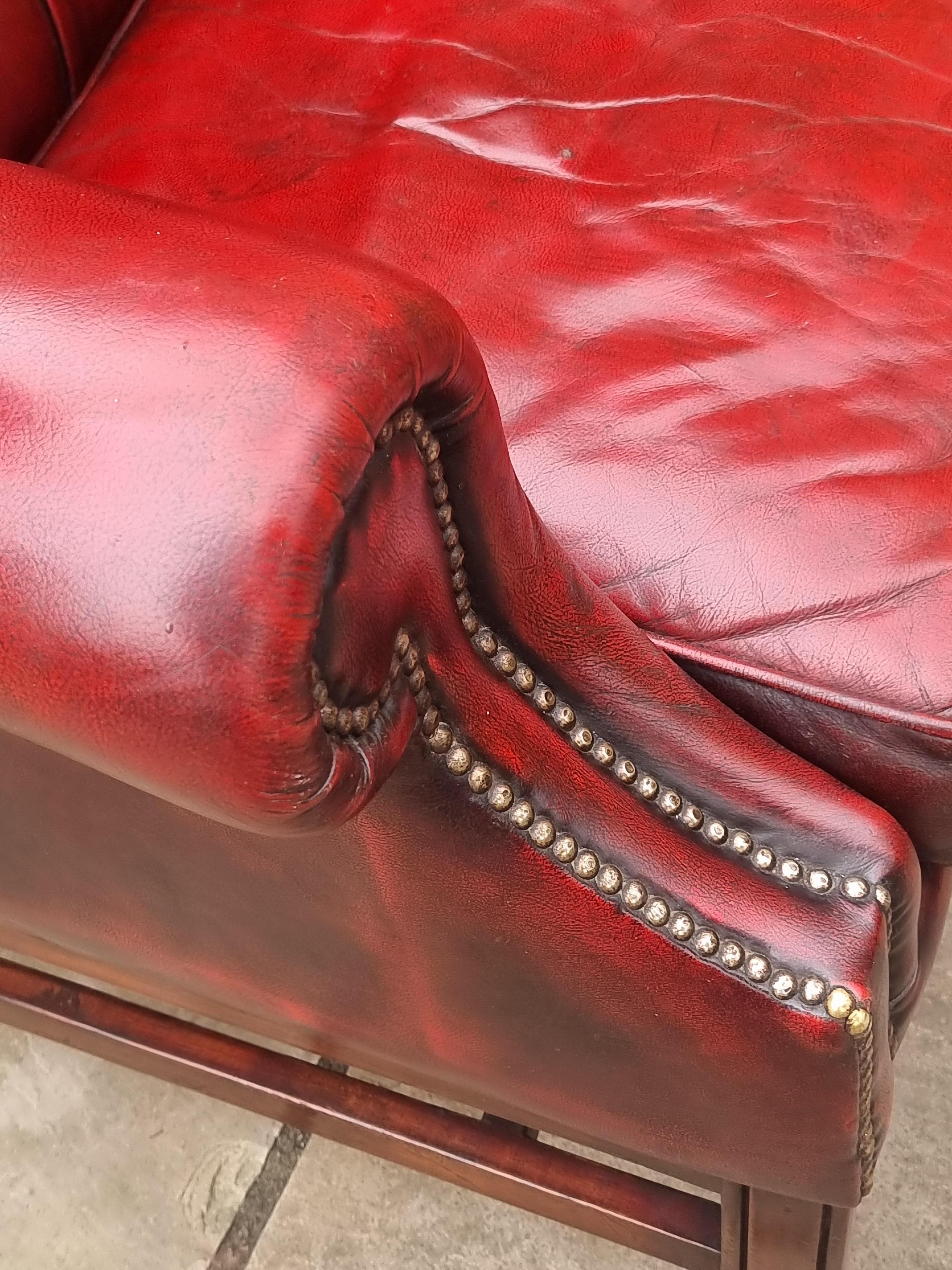 20th Century Winged armchair upholstered in deep buttoned red leather, English 1930 For Sale