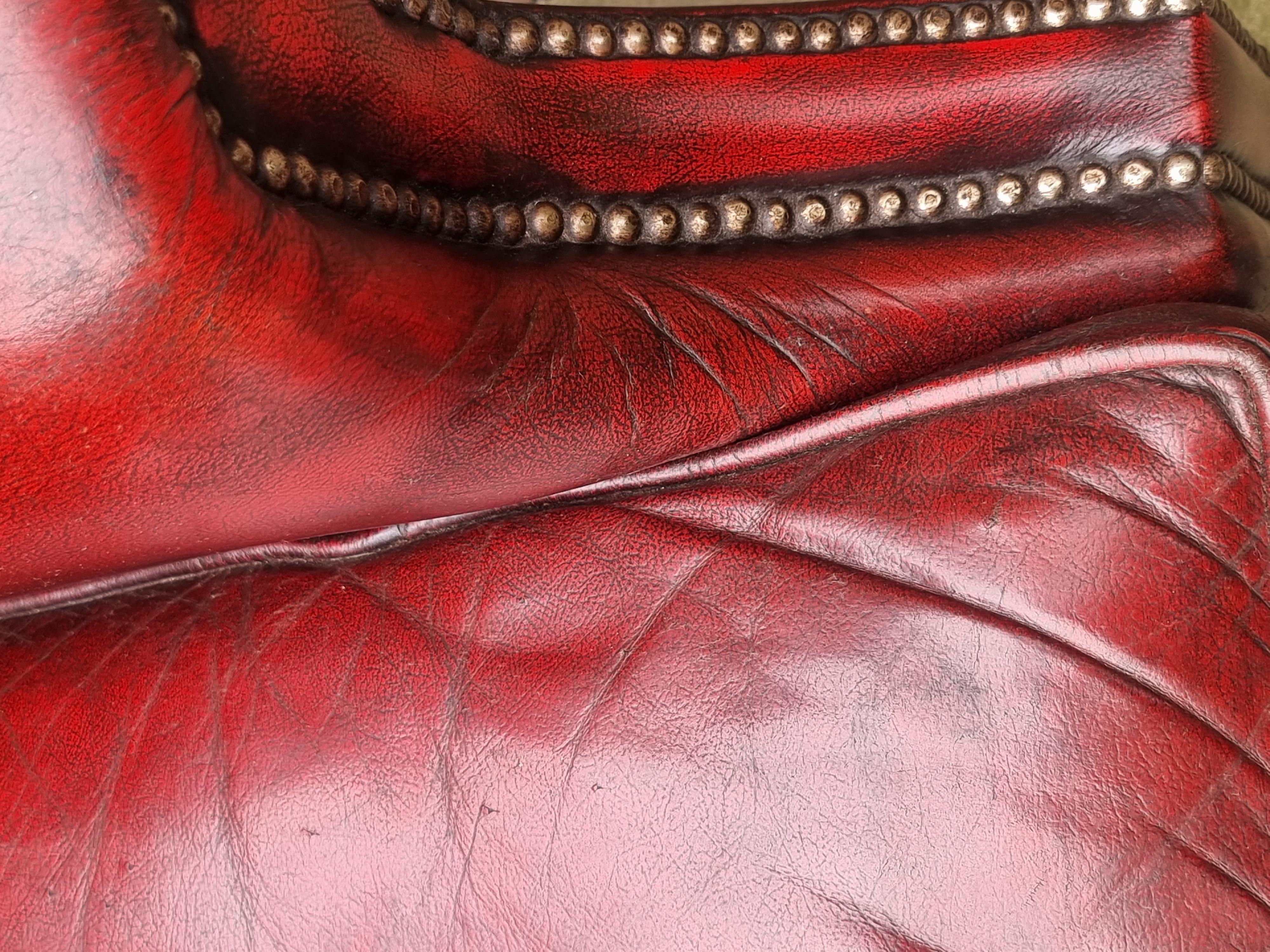 Leather Winged armchair upholstered in deep buttoned red leather, English 1930 For Sale