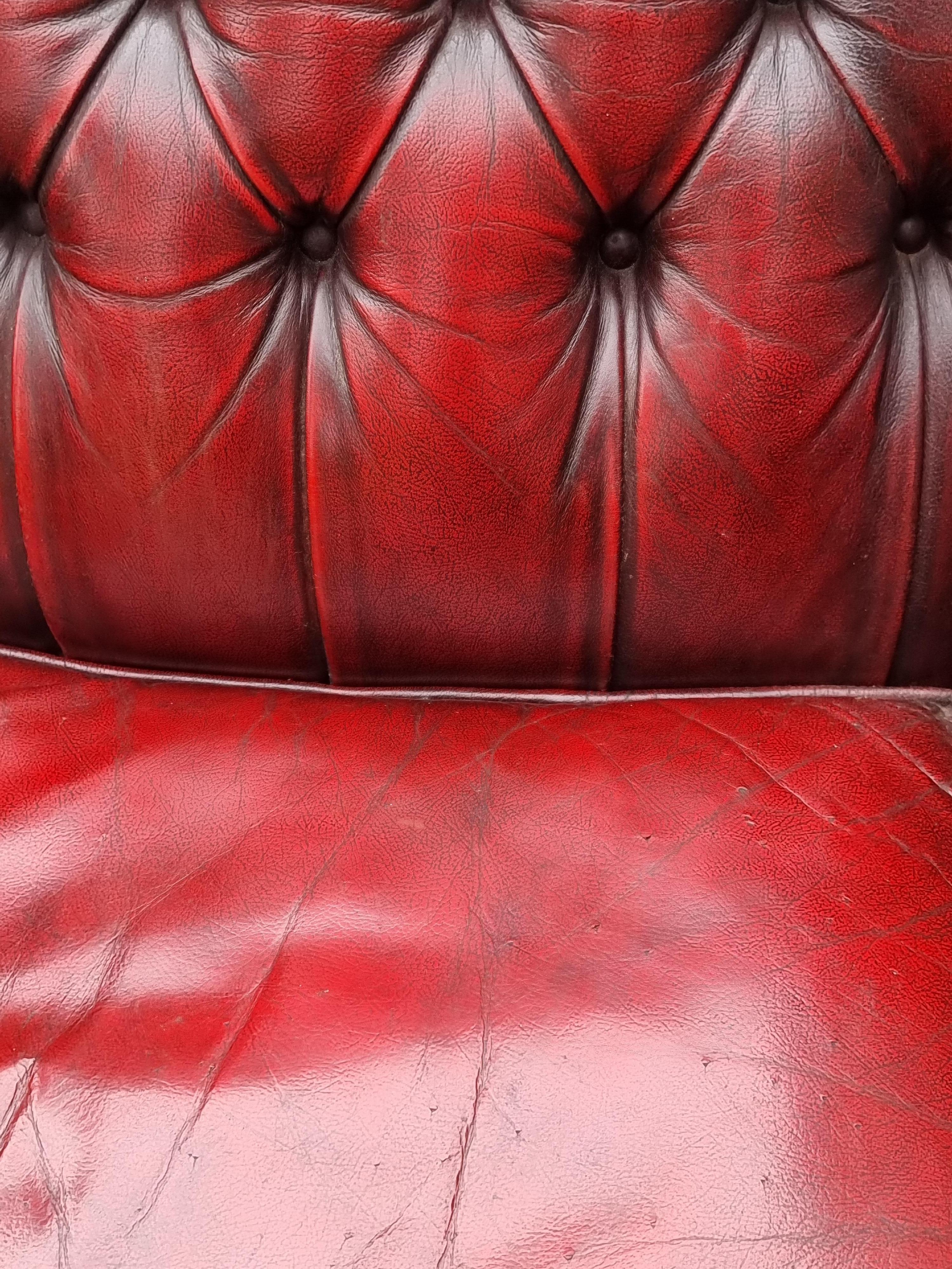 Winged armchair upholstered in deep buttoned red leather, English 1930 For Sale 1