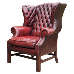 Winged armchair upholstered in deep buttoned red leather, English 1930