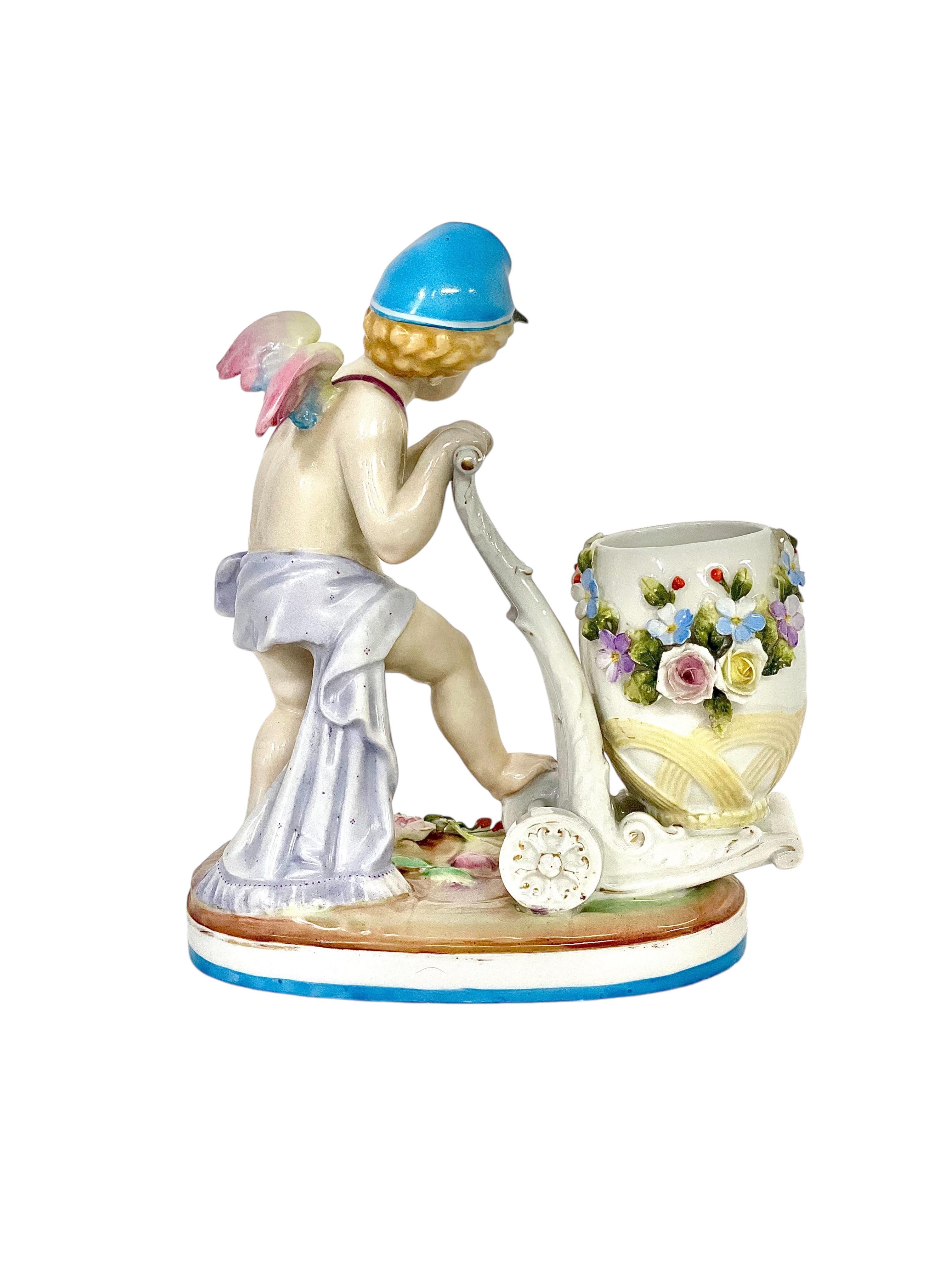 Questo adorabile angioletto alato, raffigurato come uno stravagante postino, è stato realizzato nello stile della celebre manifattura tedesca Meissen. Completo di cappellino blu e cartella rosa, questo angelico putto di porcellana si muove con la