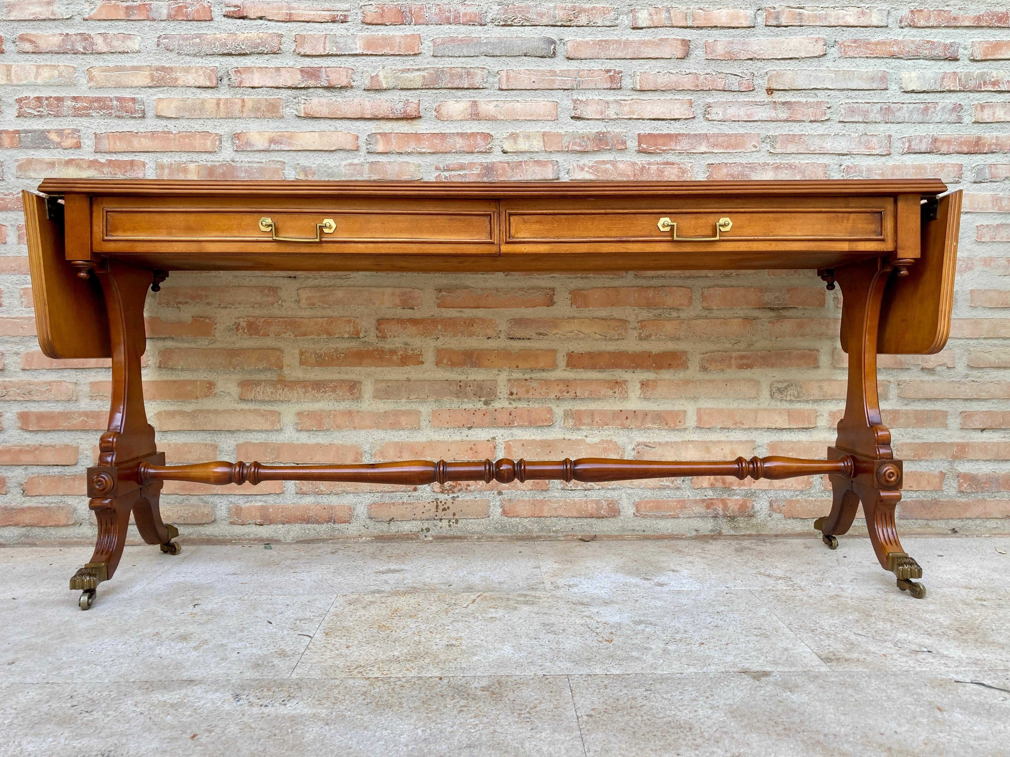 Mid-20th century winged console table in walnut with claw feet in bronze, two drawers and wheels.

Fabulous walnut inlaid console table from the mid-20th century.
Wonderfully preserved board with its knots in its root walnut wood.
Two perfectly