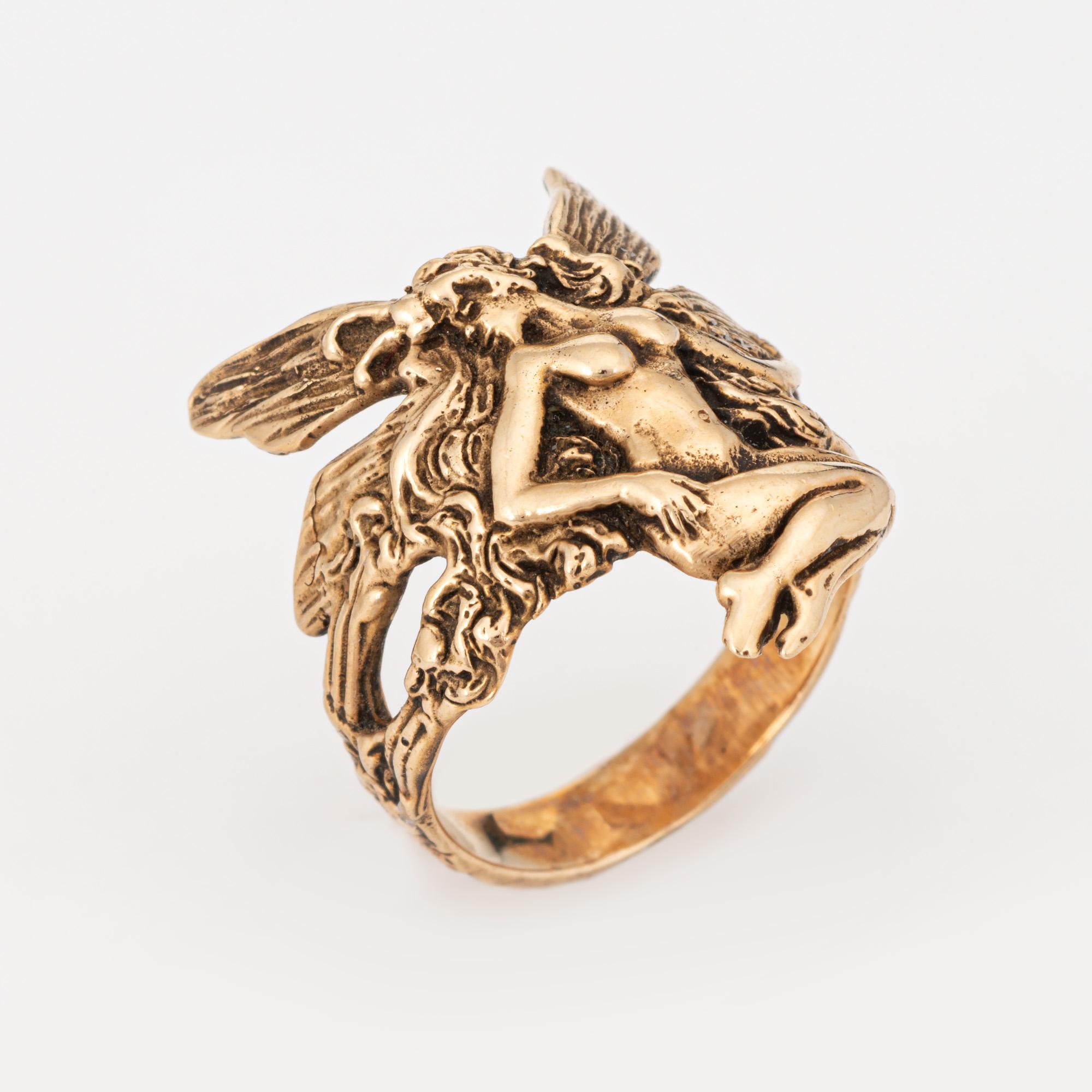 Stylish and finely detailed fairy ring crafted in 14 karat yellow gold. 

The ethereal ring depicts a winged fairy in sitting pose. The magical ring makes a nice statement on the hand. The low rise ring (2.2mm - 0.08 inches) sits comfortably on the