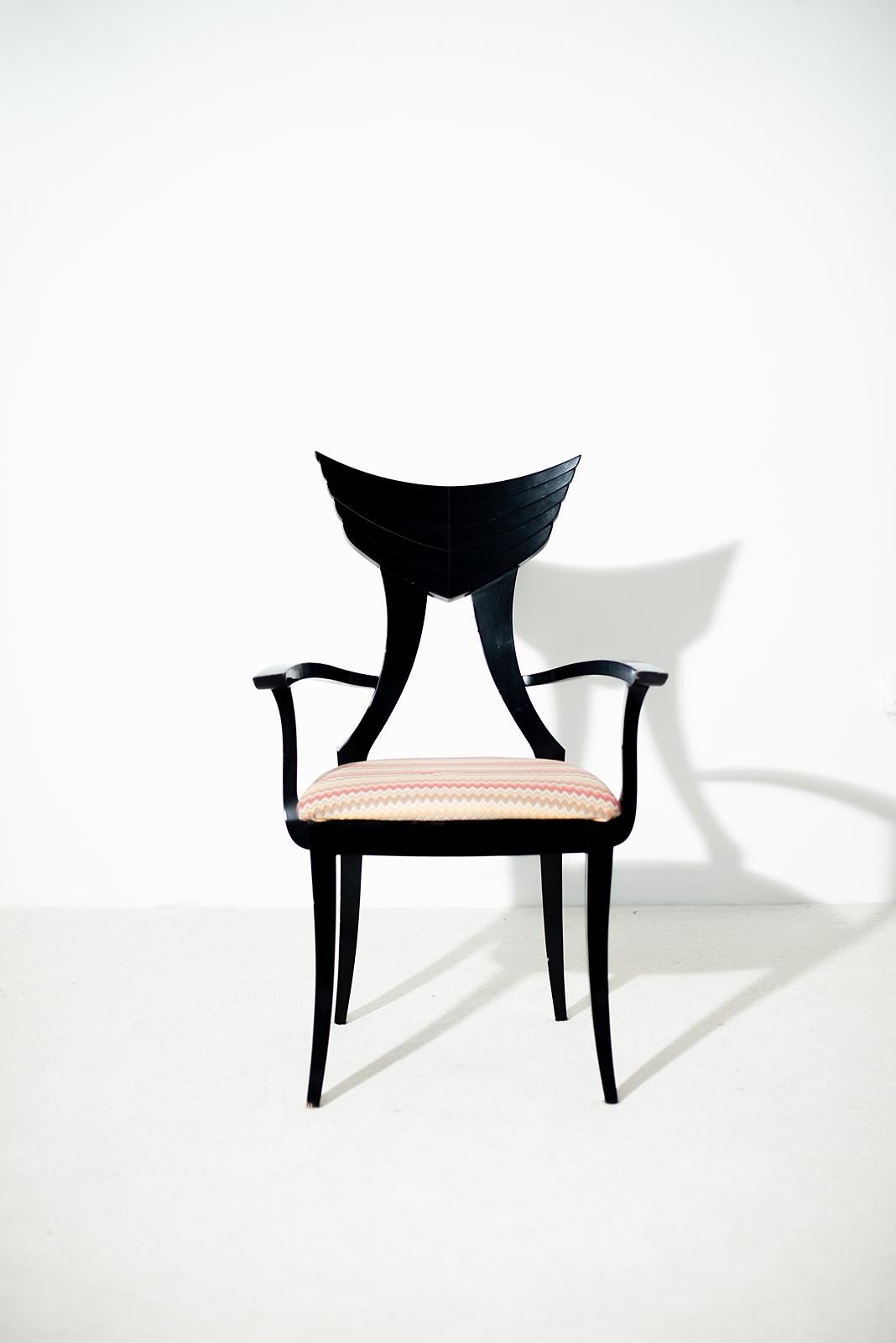 Beautiful and unique vintage Italian black lacquered wooden armchair designed by the renowned furniture designer Pietro Constantini. The chair features a wood backrest shaped like wings and a modern, cheerful upholstered seat. It is in excellent
