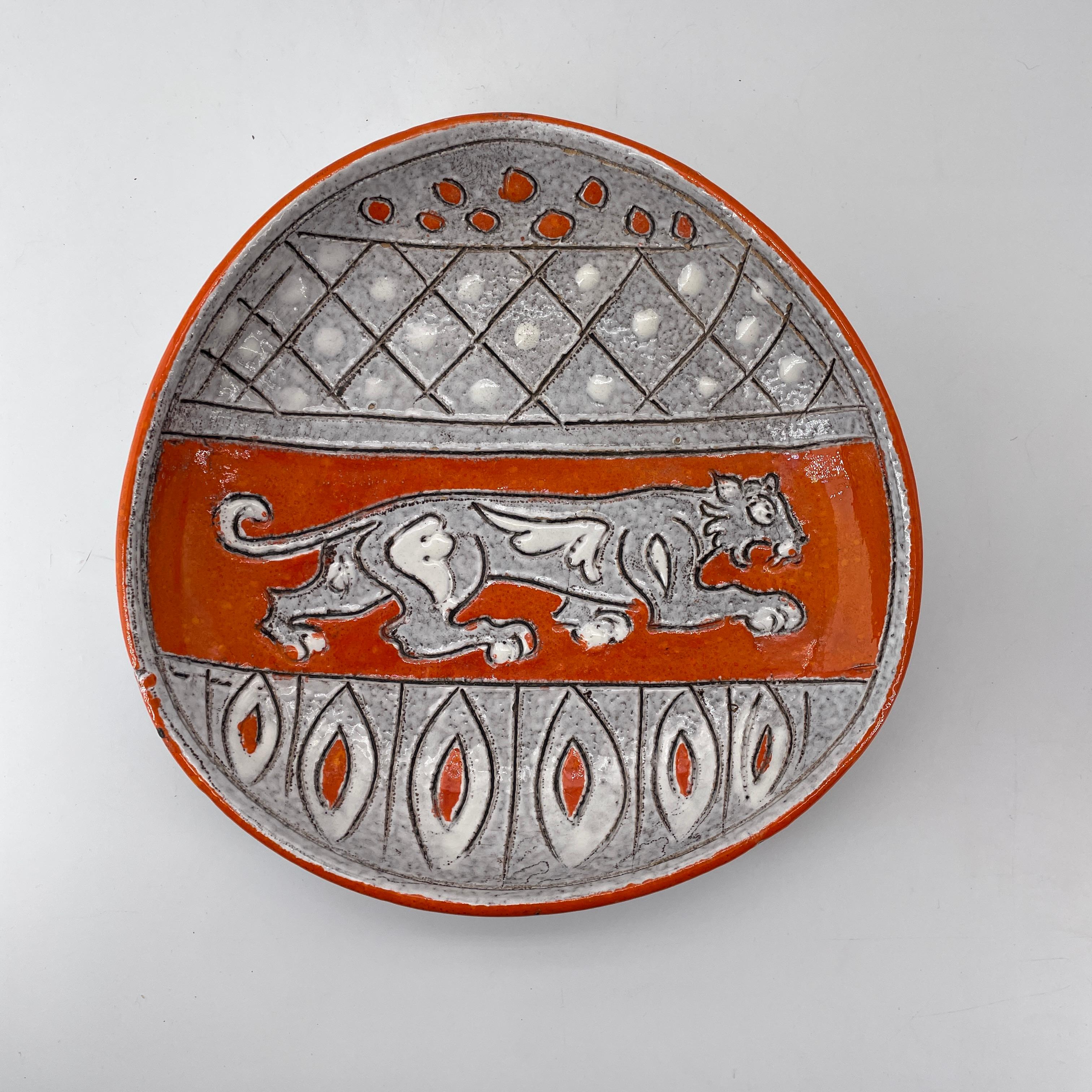 Magnifique plat pour décoration de table basse avec un lion étrusque dans une disposition héraldique des armoiries. Pas d'éclats, ni de fissures, mais quelques sauts de glaçure, naturels à la fabrication, et illustrés. Signé sur le fond dans la