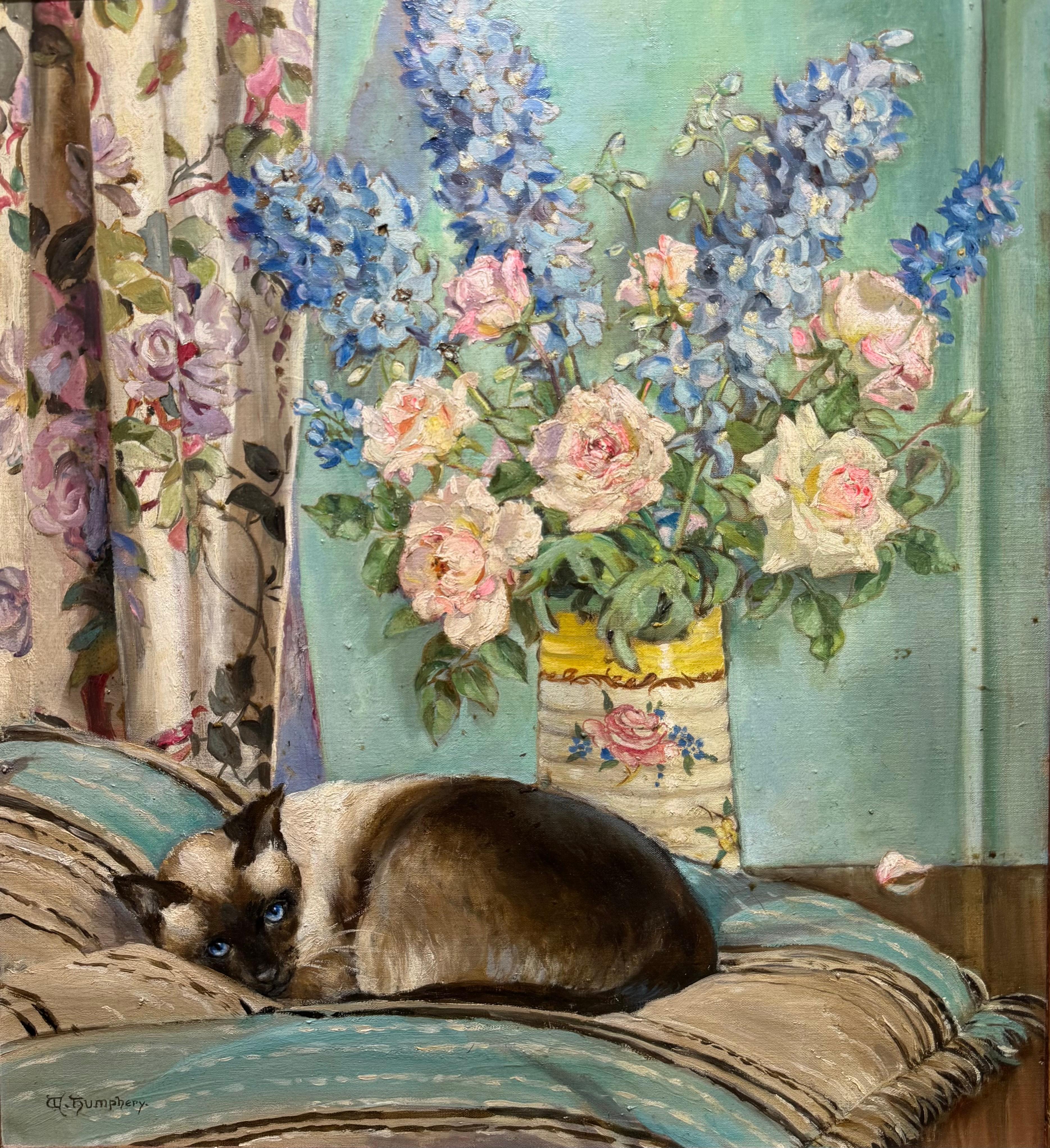 Winifred Humphrey, an early 20th century female English painter and founding member of the St. Ives Society of Artists. 

This exquisite oil on canvas depicts a cozy domestic scene with a SIAMESE CAT and colorful floral details rendered in soft