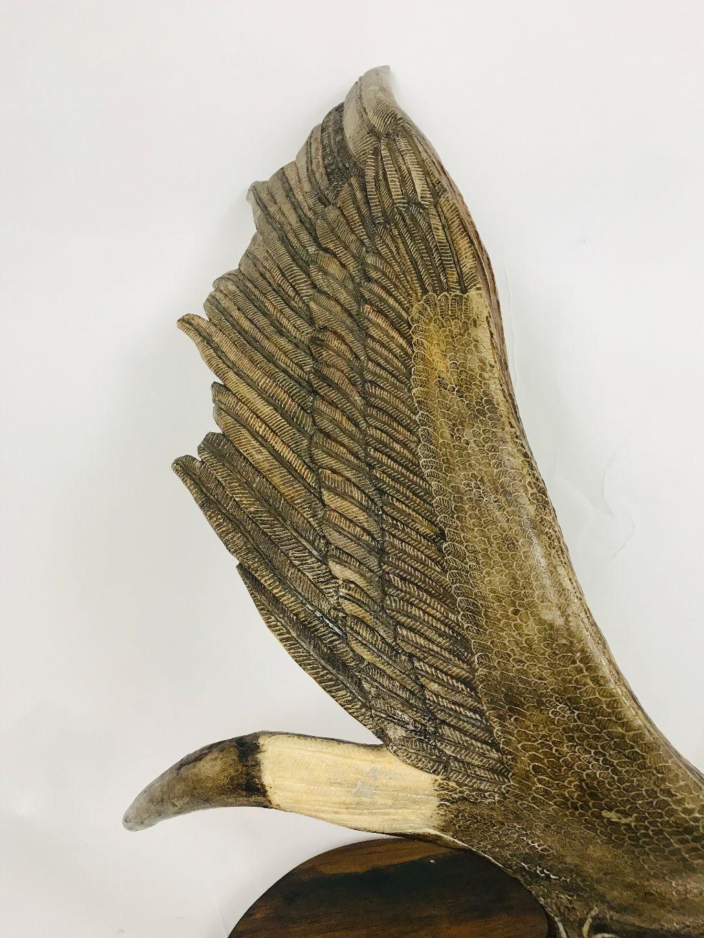 This elk Horn which has been carved into an eagle in flight is a dramatic and unusual piece. It is attached to a wooden base with a plaque which reads 