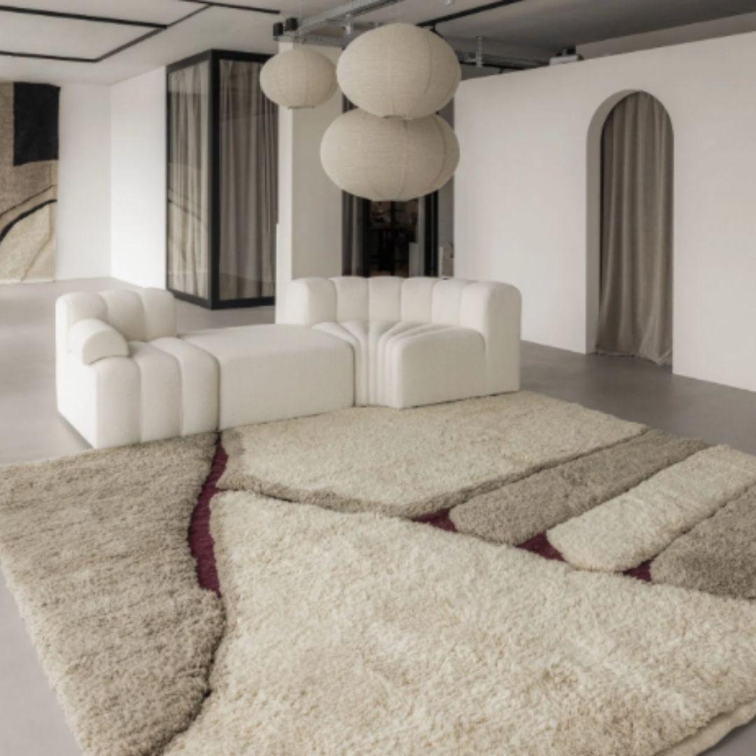 This incredibly fluffy, handwoven wool rug features a stunning contrast between its high-pile ivory wool, accented with soft touches of taupe, and a rich, flat-woven river in a deep wine hue.

The dense, cloud-like texture invites warmth and