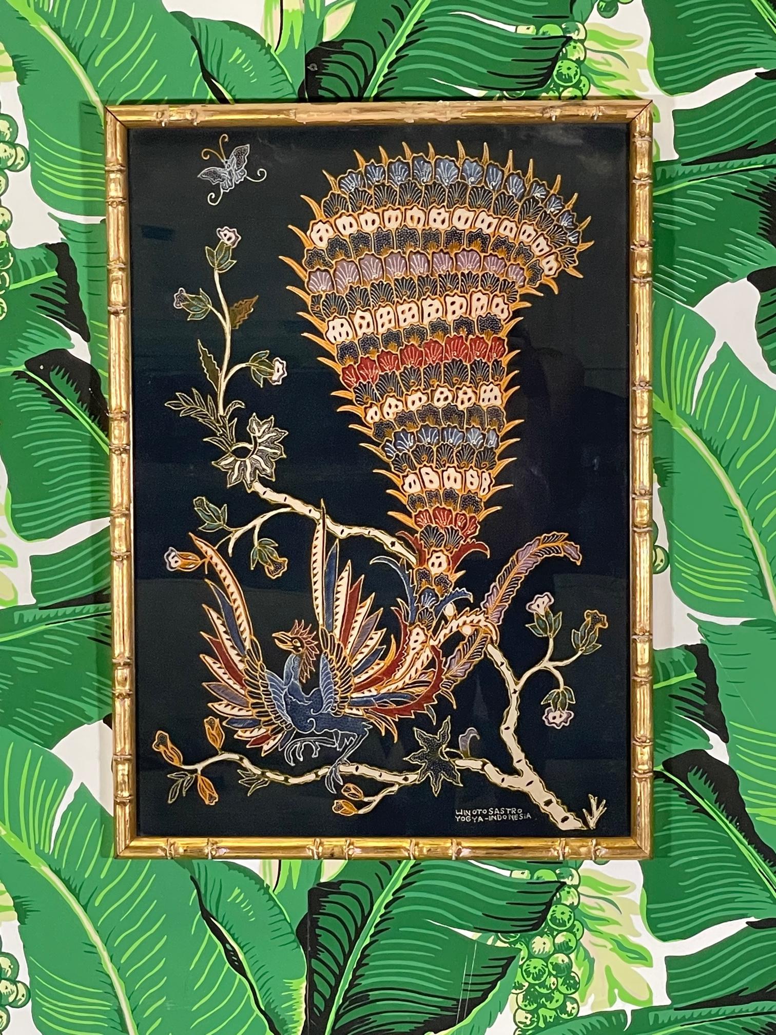 Framed Indonesian batik print by Winotosastro. Framed in gilded faux bamboo carved wood. Beautiful Southeast Asian artwork featuring an exotic bird of paradise with colorful plumage. Good condition with imperfections consistent with age, namely wear