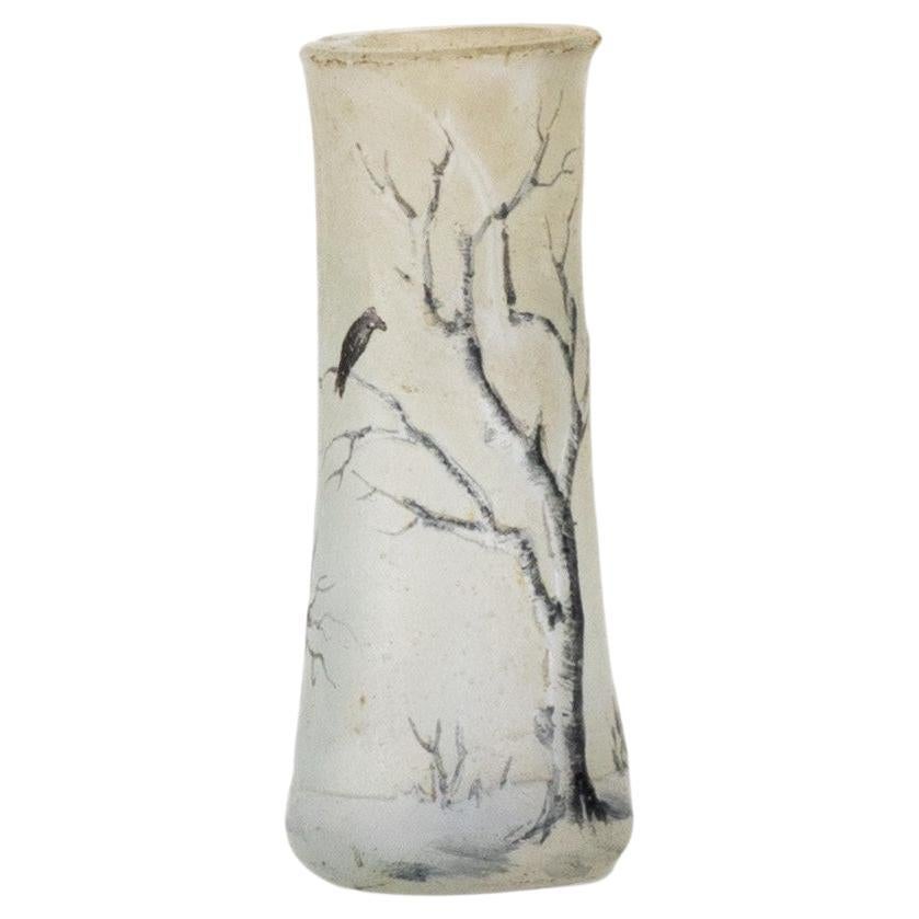 Mehrschichtige Miniaturvase aus Glas mit säuregeätztem und polychrom emailliertem Dekor auf grau schattiertem Hintergrund mit einem Winterbaum mit
Brauntöne und schneeweiße Details. 

