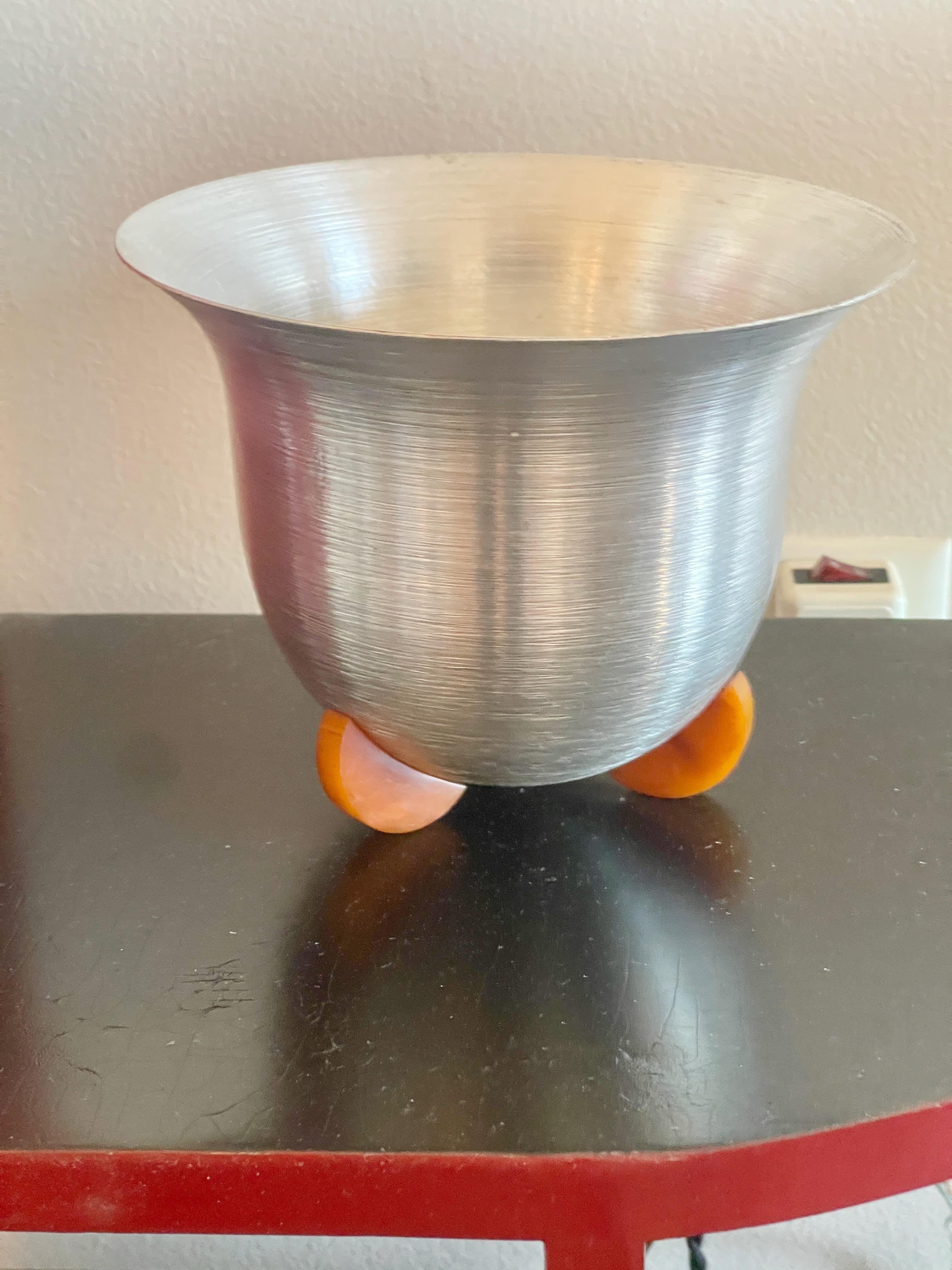 Cubitera americana art déco de aluminio hilado y baquelita marcada WIRA Nueva York.
Existe muy poca información sobre la empresa, aparte de un anuncio en el Libro Azul de Mercancías de Calidad de 1936: 