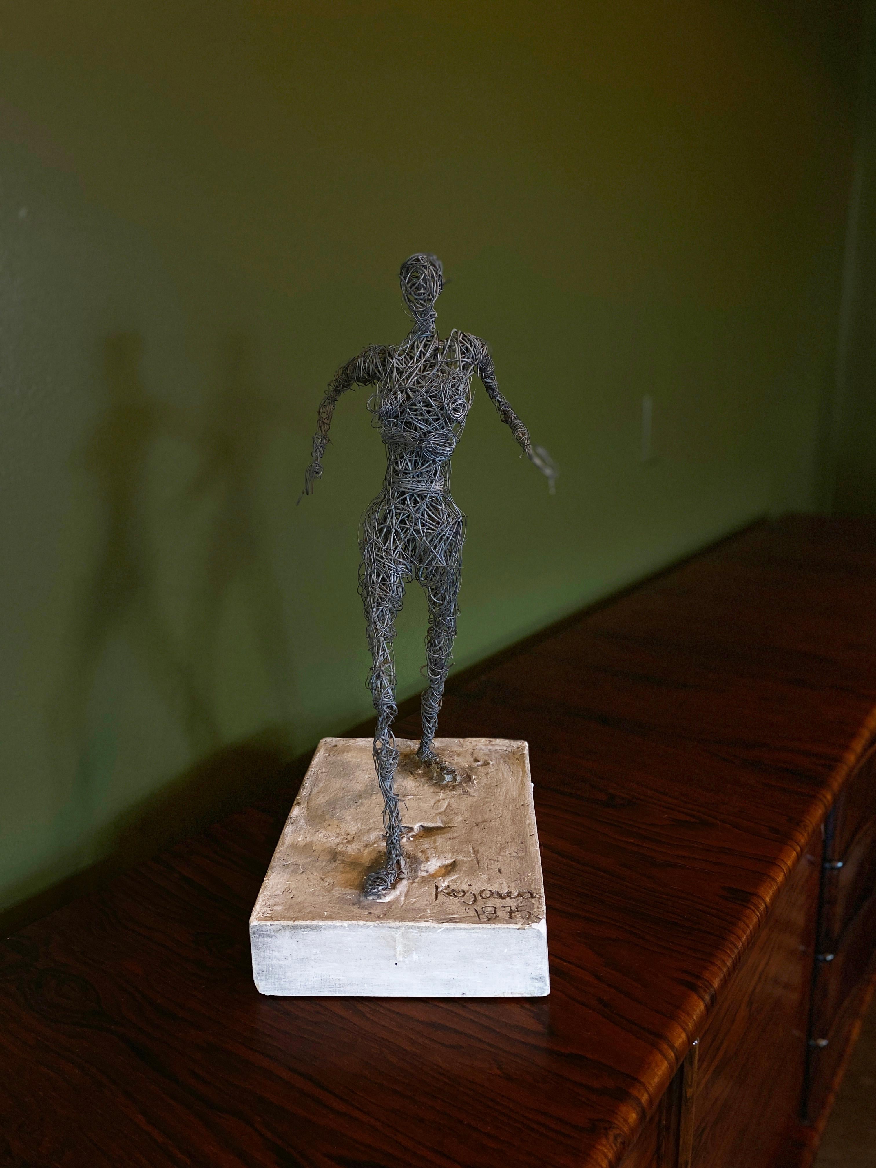 Female figure sculpted in wire on cast concrete base, signed Kujawa 1975. Kujawa was a student of the famed French sculptor Cesar Baldaccini. One of three unique figures available. 

Other two figures listed