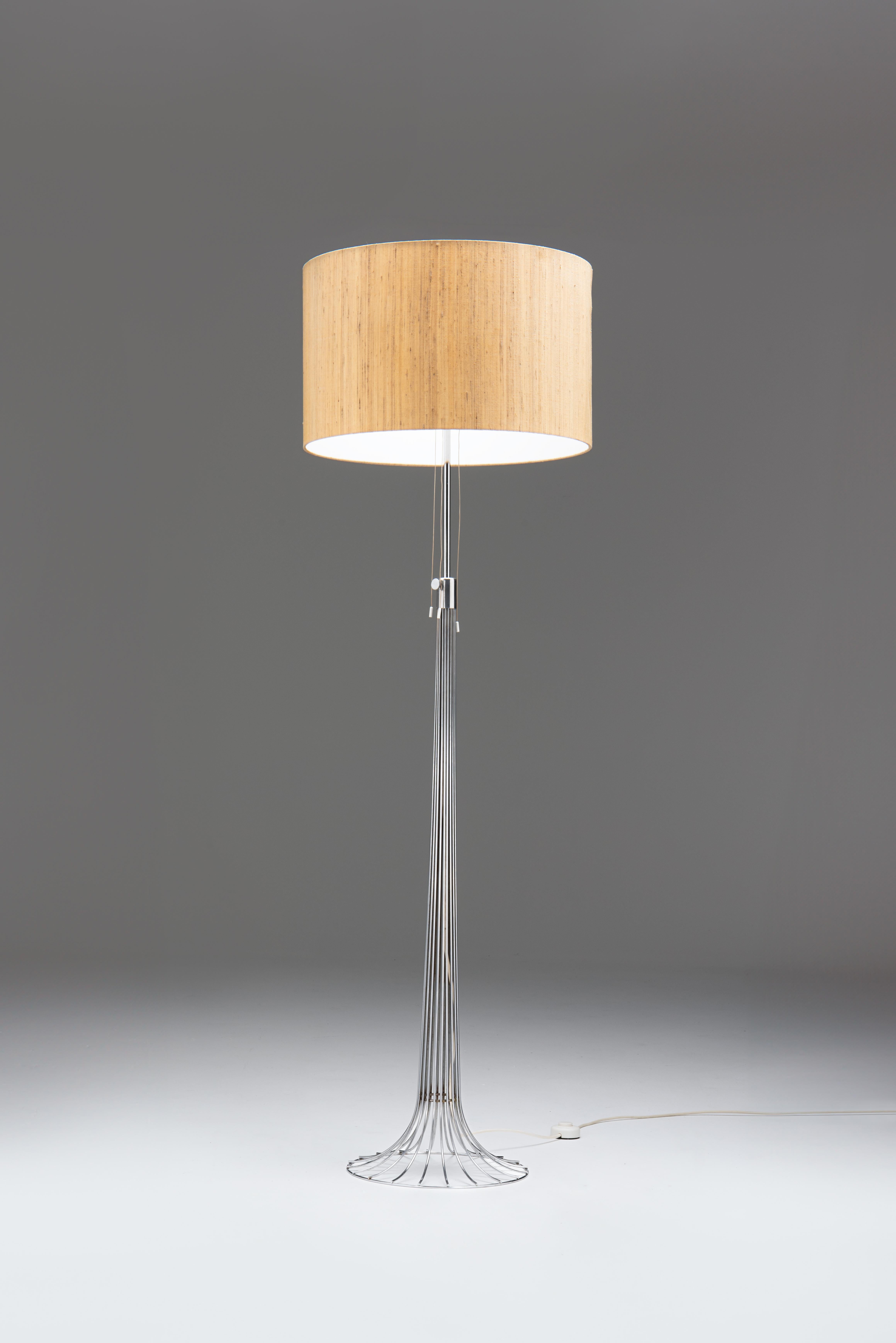 Eine hochwertige Stehleuchte aus verchromten Metalldrähten in Trompetenform. Diese ungewöhnliche Lampe wurde wahrscheinlich Ende der sechziger Jahre entworfen und von Kinkeldey-Leuchten in Bad Pyrmont hergestellt.
Der Lampenschirm ist noch in seinem