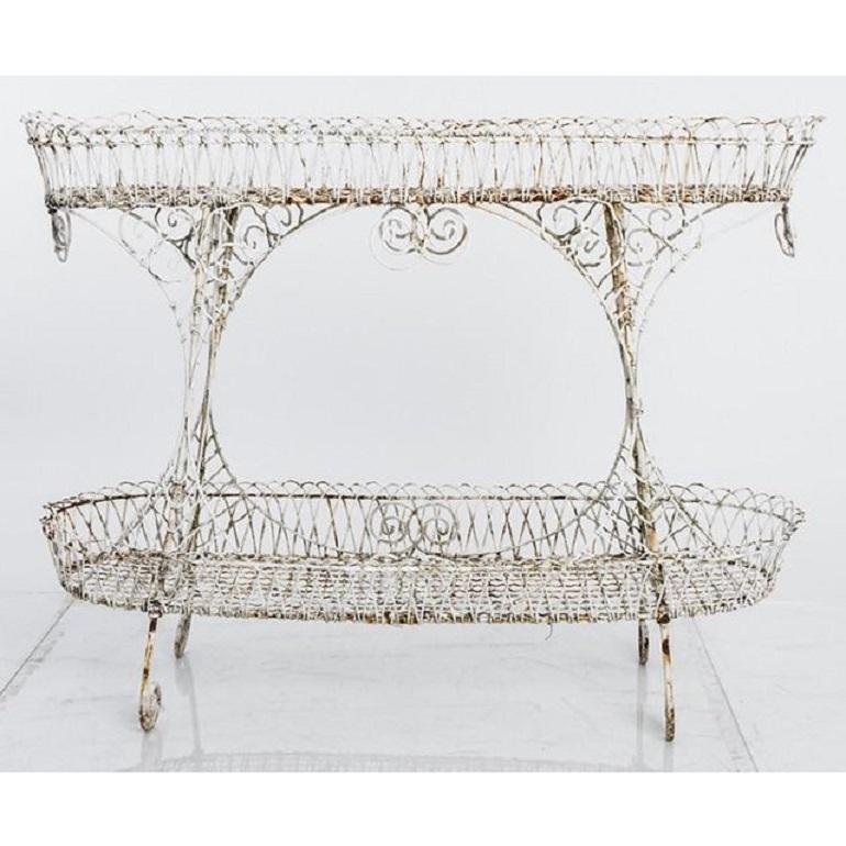Classic antique white Victorian wire planter made in England circa 1850. Wire basket plant holders are decorated with elaborate scrollwork. A staple in English greenhouses in the 19th century, the two-tiered plant stand allows for creative display