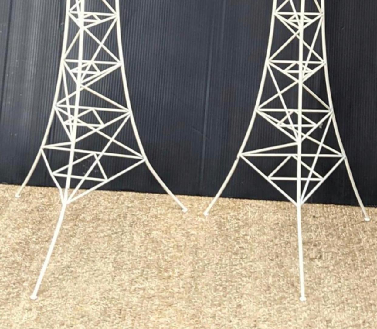 Unusual and unique Eiffel Tower style floor lamps. Wire rod framing with white coating. Wear and tear including paint loss. Lamps will need to be rewired and could be recoated. Sold as is for reimagination.