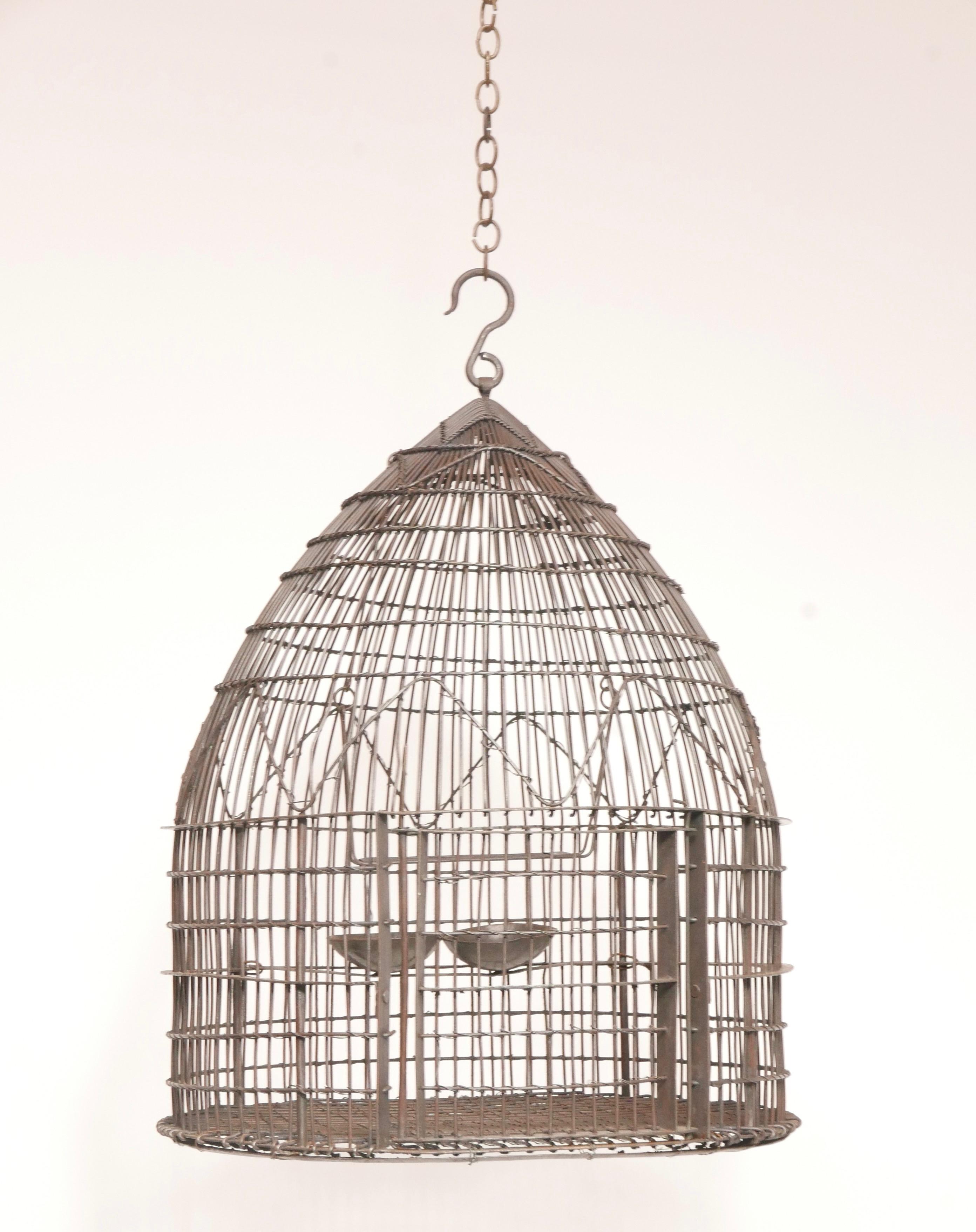 A very unique iron and wire wrapped bird cage. Dome shaped, with interior feeders and perch,
19th century, possibly Chinese.
  