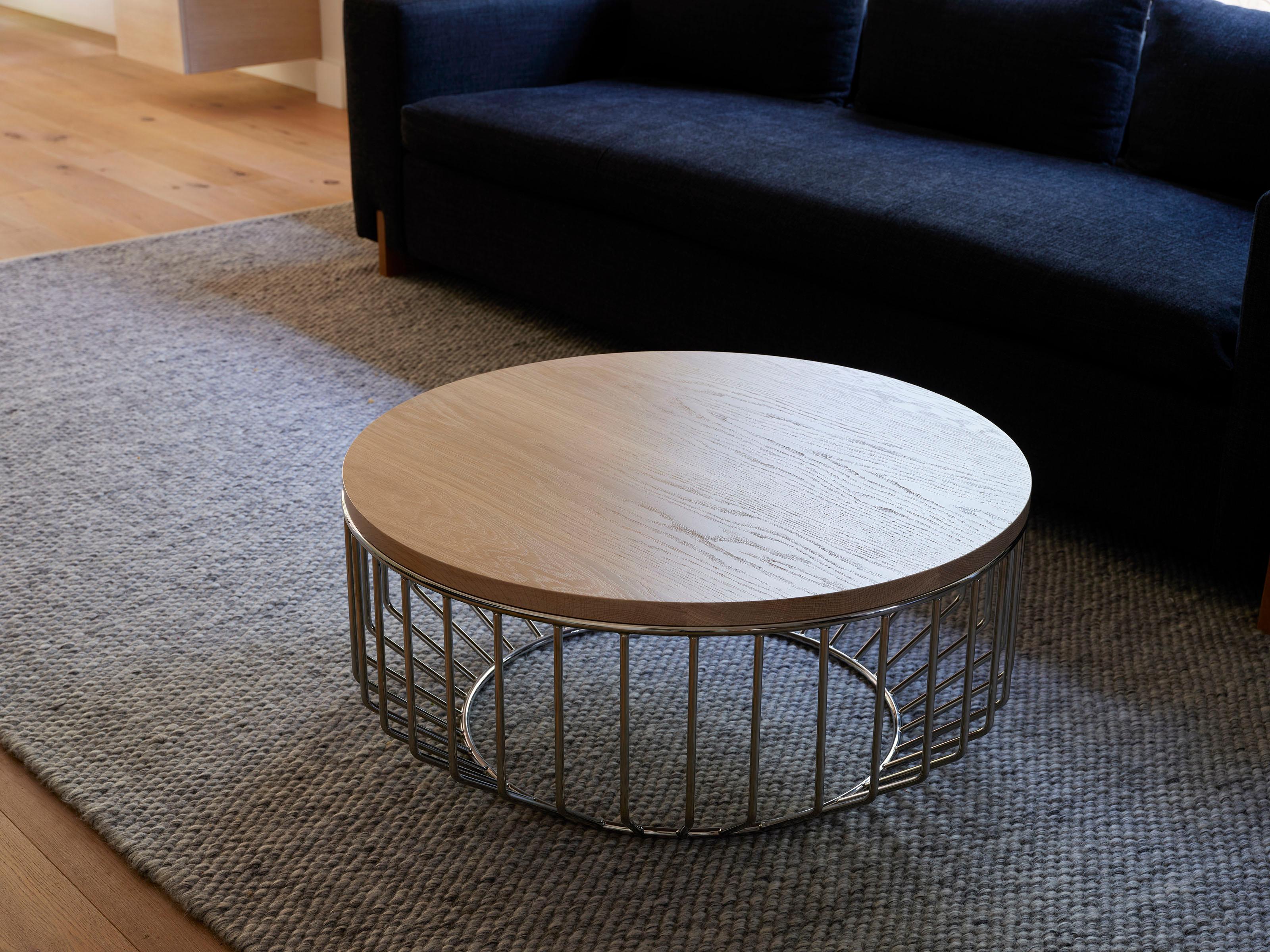 Blending sloping angles and taut lengths of bent metal are a modern interpretation of the wiry idea initially conceived by Warren Platner. The series is made up of a suite of tables, side tables and benches and fitted with luxurious solid wood,