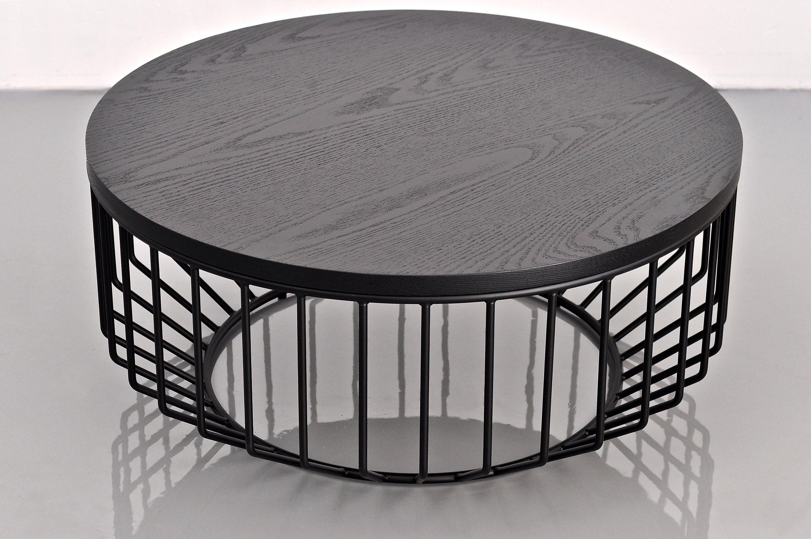 Wired Coffee Table by Phase Design
Dimensions: Ø 81.3 x H 35.6 cm. 
Materials: Powder-coated metal and ebonized oak.

Solid steel bar with glass, upholstered, or solid wooden tops, available in walnut, white oak, or ebonized oak. Steel available in