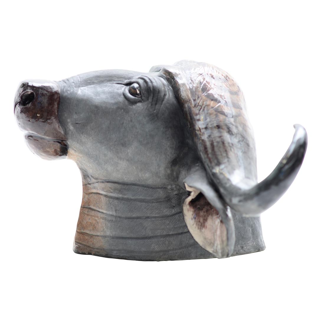 Introducing the Wiseman Ceramics Buffalo Bust, a stunning piece hand-sculpted by Thabo Mbhele and painted by Wiseman Ndlovu. From the celebrated Big Five Collection emerges a captivating hand-sculpted bust, skillfully capturing the commanding
