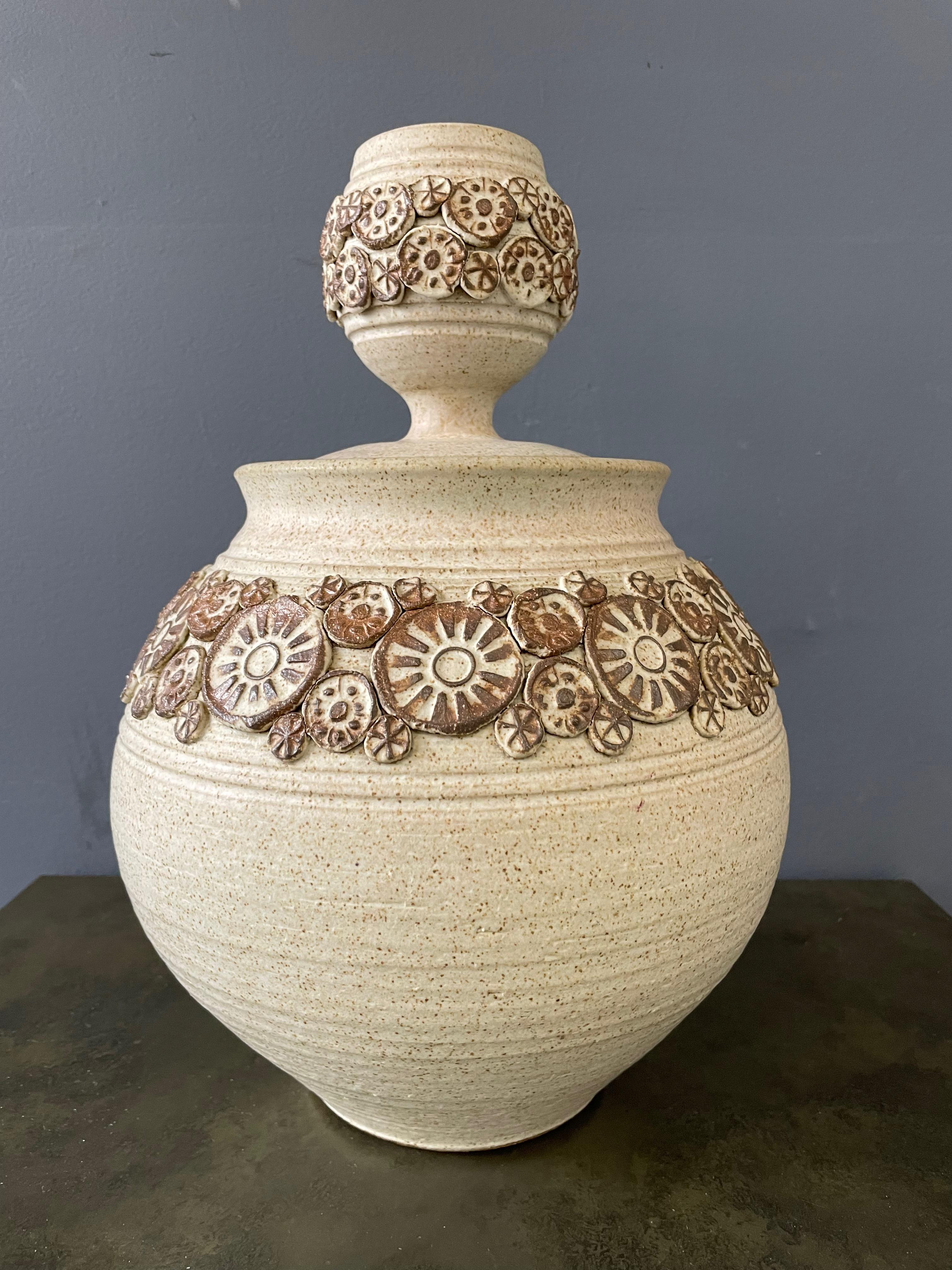 Vessel is instantly recognizable as the work of Wishon-Harrell artist Frank Wilett. The circular appliqué pieces are instantly a giveaway. The lid is an unusual shape that mimics the base and makes this piece incredible.