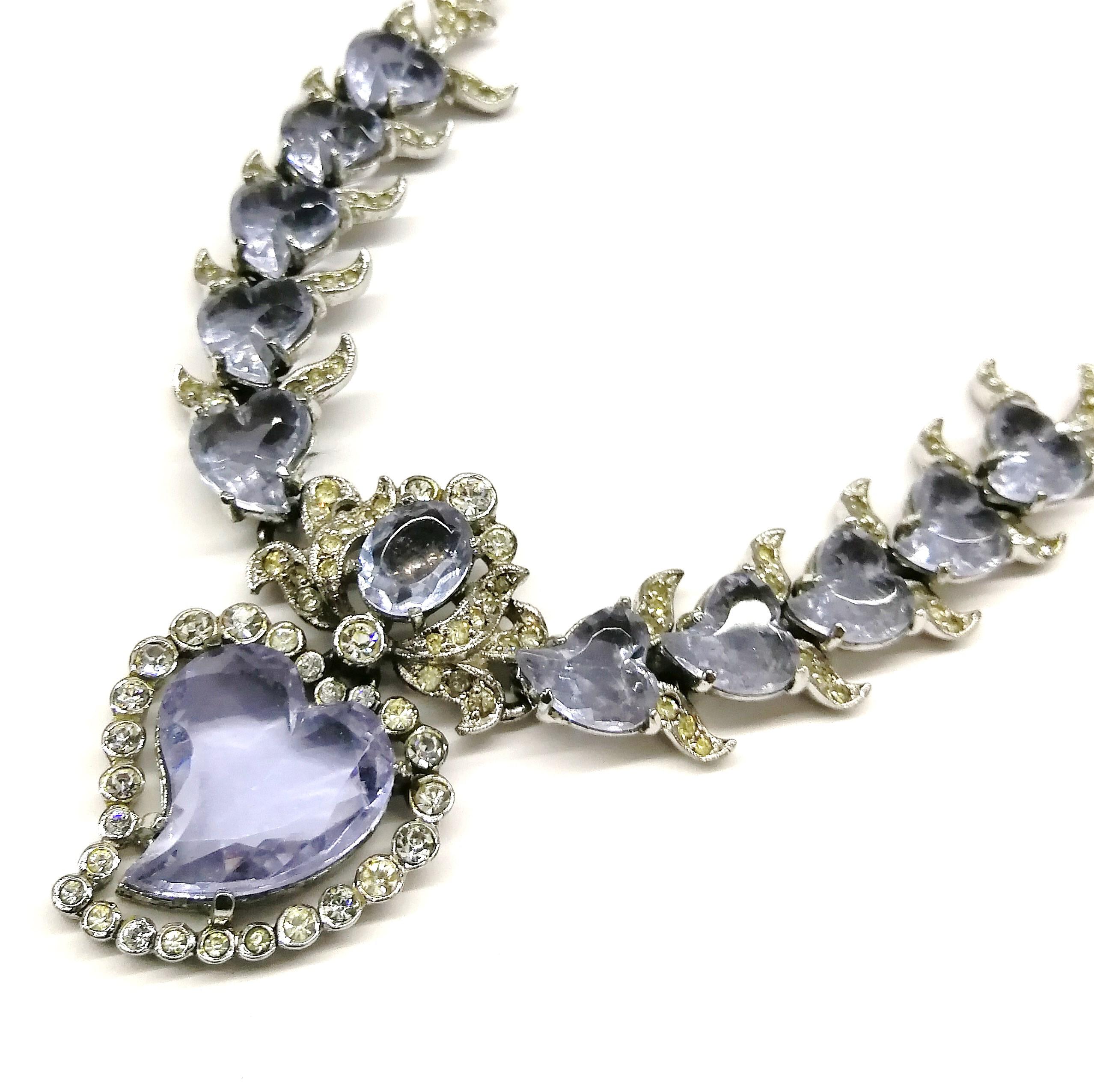 An exquisite and rare parure, a necklace, bracelet and matching earrings, made by Mitchel Maer for Christian Dior in the early 1950s. Made from clear pastes, and set with soft lilac moulded glass 'witch's hearts' - a traditional heart, 'twisted' at