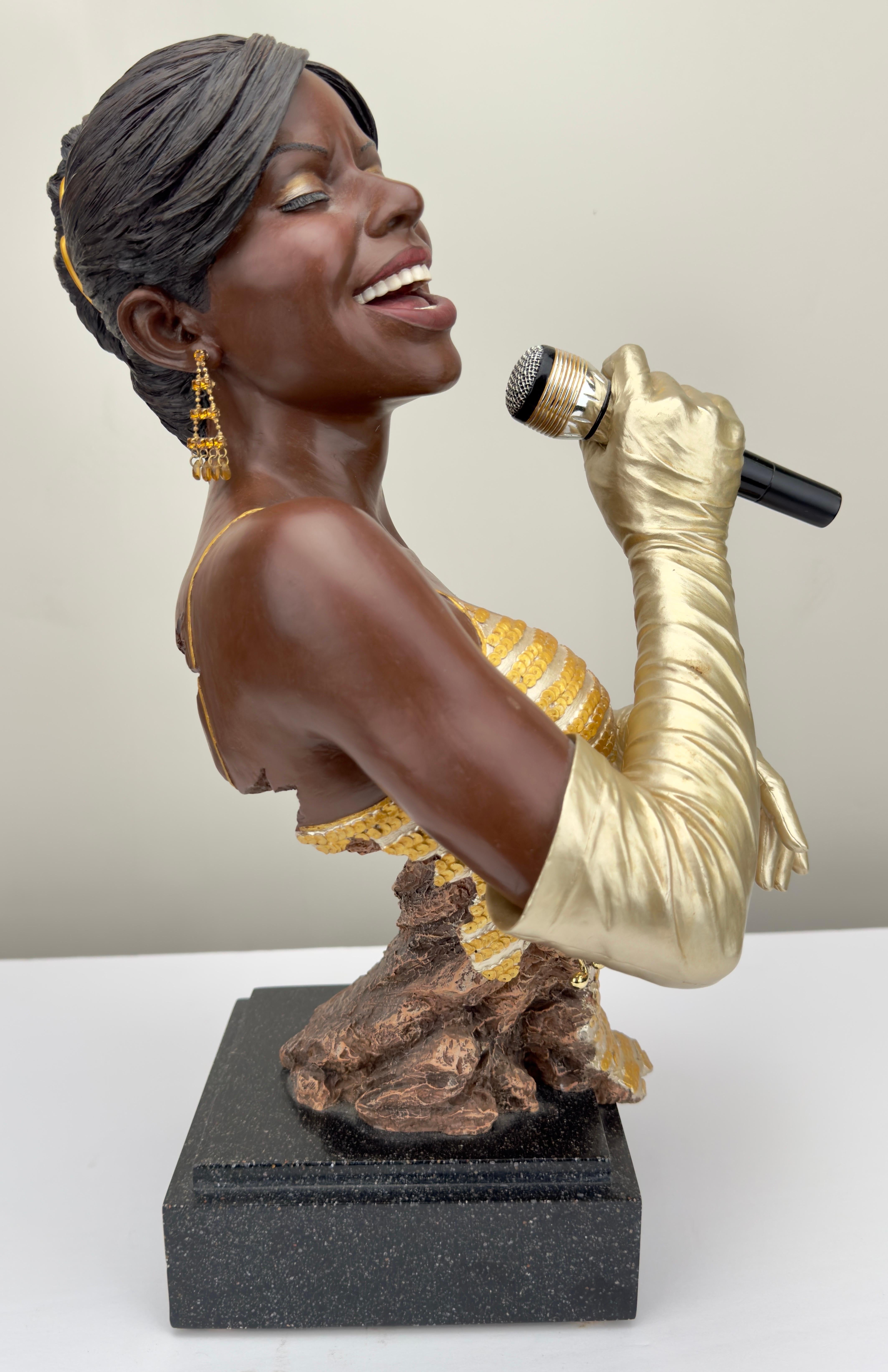 Une impressionnante sculpture de chanteuse de jazz en or, réalisée par Willitts Designs International et Shen Lung. La sculpture est peinte à froid et réalisée en résine coulée à la main. La chanteuse porte des gants en or, une robe en or et des