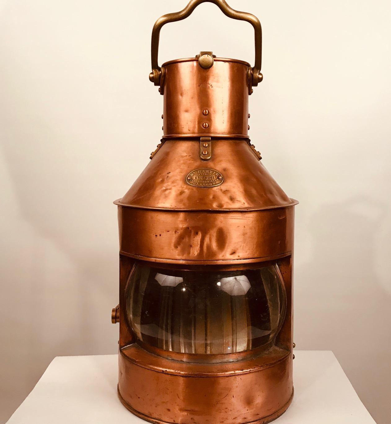 A copper and brass signal light by William Harvie & Co Ltd, Glasgow, numbered 6620, constructed in copper and brass with clear bulls eye lens, shutter handle, the chimney stamped Wm Harvie 1903 and brass plaque to front reading W HARVIE patentee