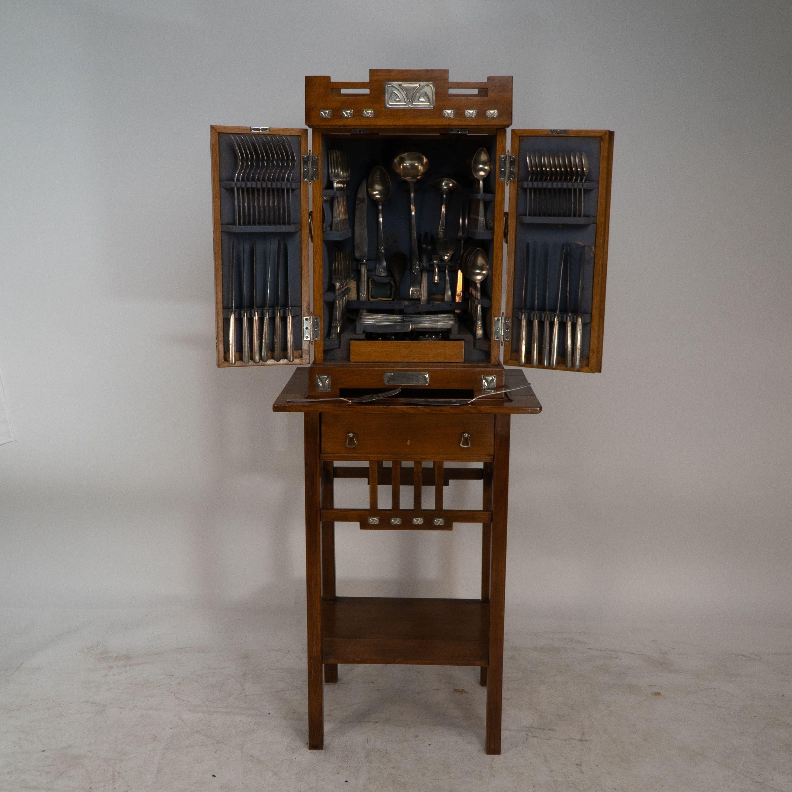 WMF Ein seltenes Besteckservice für 12 Personen in einem originalen stilisierten Eichenschrank aus der Sezessionszeit mit einer Schublade, unterer Ablage und stilisierten versilberten Beschlägen und Griffen. Die untere Platte mit Platz für eine
