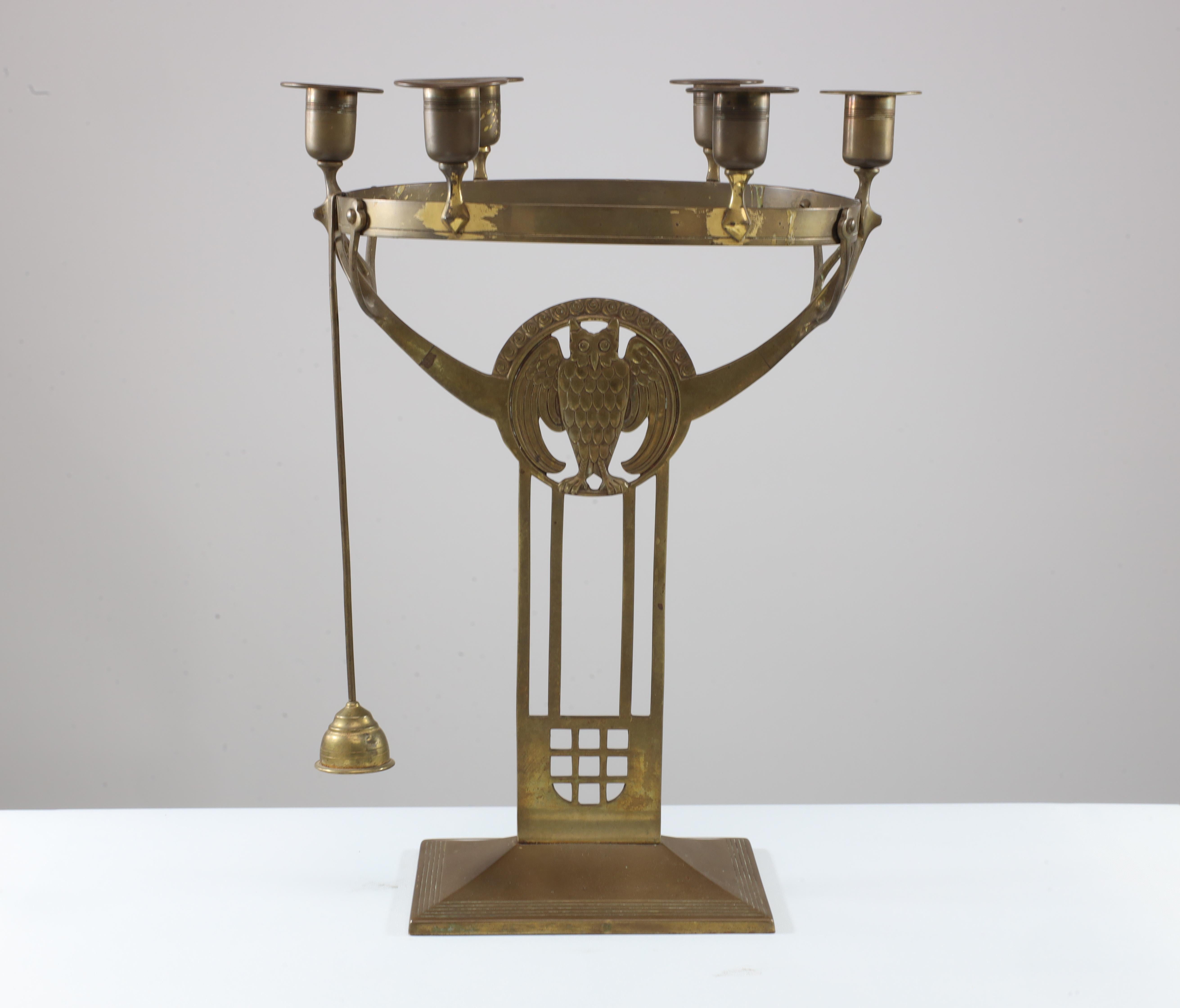 WMF attributed. An Art Nouveau candelabra with six sconces to the main circular ring and sineous supports that meet the arms which rise from the sides of the wise old owl in the center, with twin double supports running down to meet the pierced
