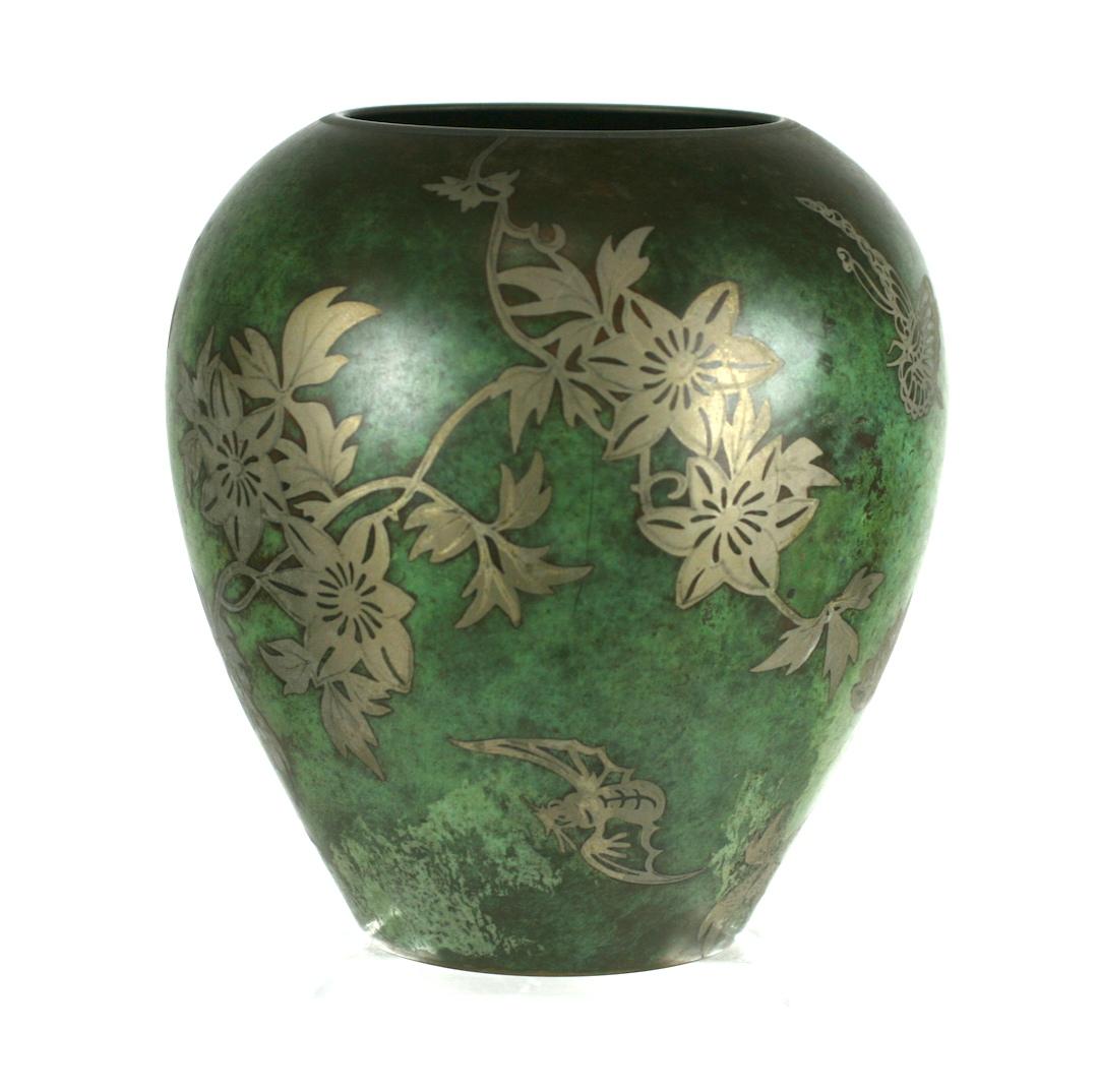 Ravissant vase Ikora en bronze patiné Art déco allemand WMF (Württembergische Metallwarenfabrik) décoré d'une fleur stylisée, de vignes et de papillons par Paul Haustein (1880-1944) et datant d'environ 1920. Le vase de forme arrondie et bulbeuse