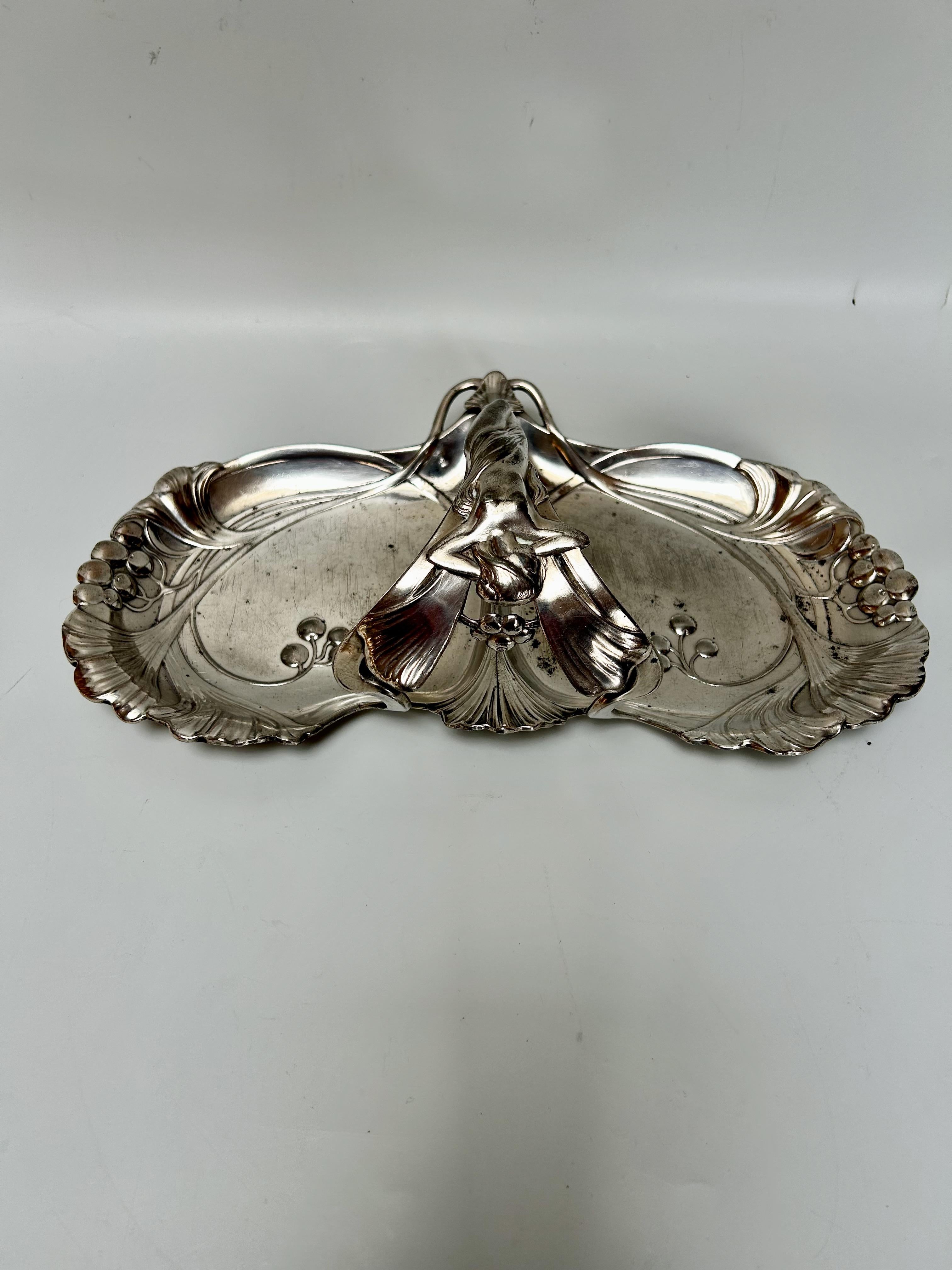 Art Nouveau aperitif server or pin tray, circa 1900.
Silver-plated metal with ginkgo biloba leaf decoration, handle decorated with a woman.
Stamped WMF.
In very good condition. Note some traces of oxidation

Total height: 9.5 cm
Width: 31.5