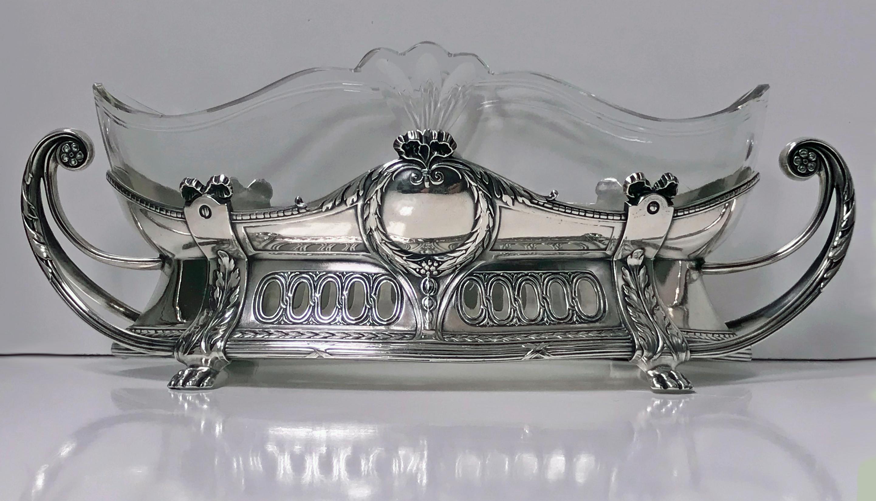 WMF centrepiece with Art Nouveau floral decoration and the original clear glass liner and silver plate. The Dish on acanthus foliate supports, curvilinear handles, the body with ovolo panel and festoon decoration. Full WMF marks to foot. Measures: