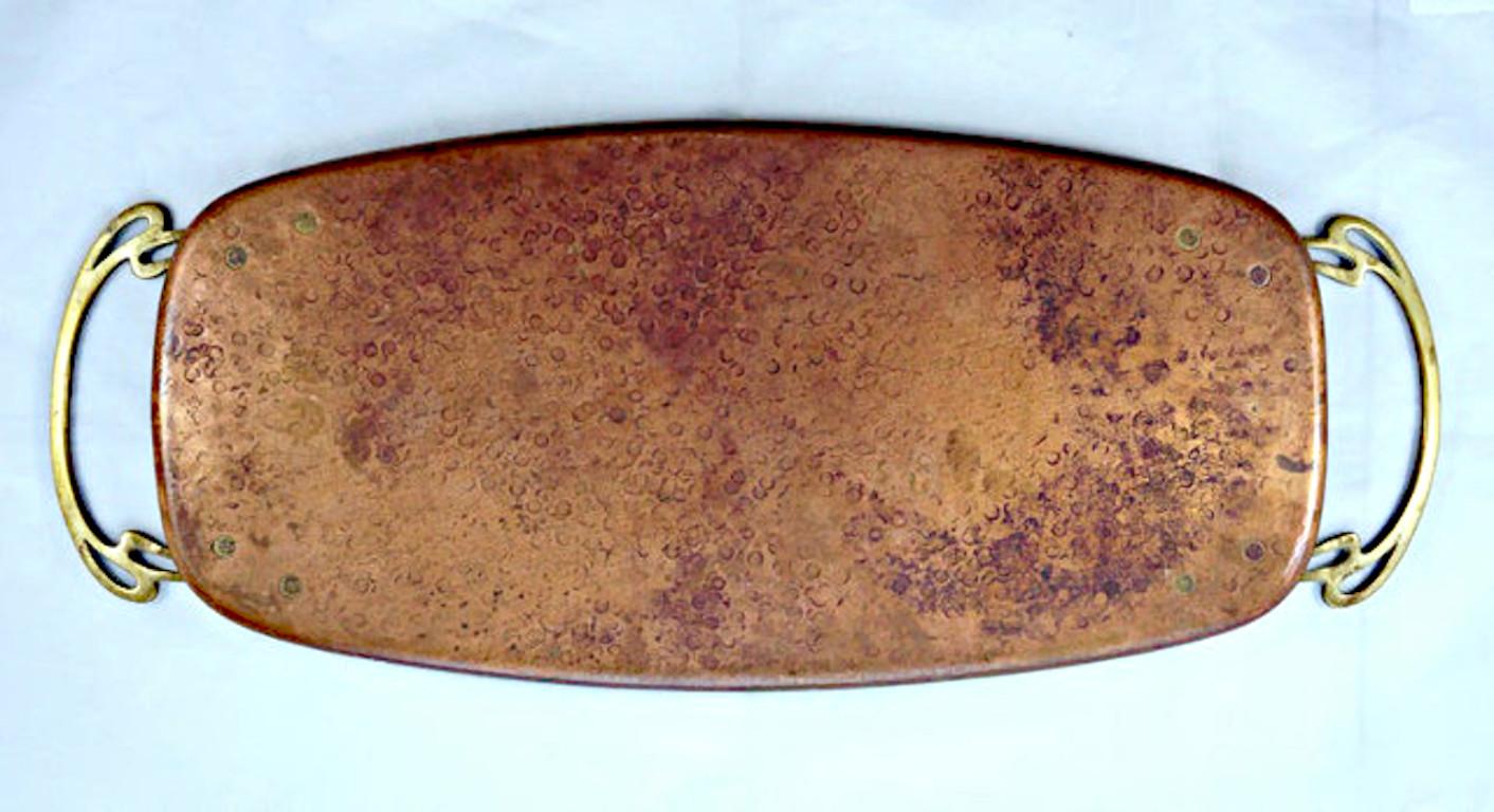 WMF Art Nouveau hand hammered copper tray with contrasting brass handles. Measuring length 48.5cm / 19.09 inches by width 19.9cm / 7.83 inches, and height 1cm / .39 inch. It is stamped with the WMF ostrich mark. The tray has age related patina, and