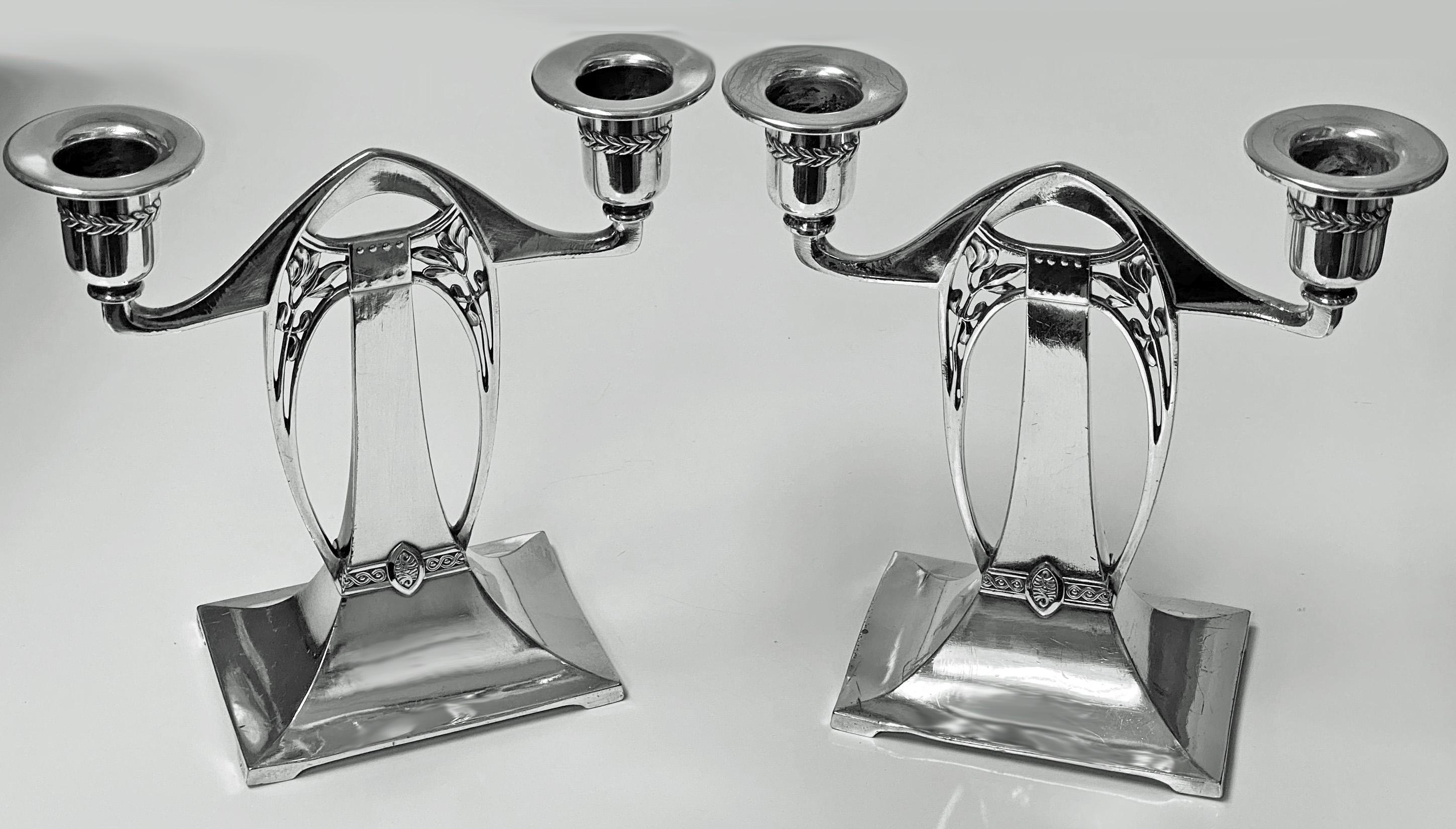 WMF Art Nouveau Jugendstil secessionist candlesticks candelabra, Germany, circa 1900. The polished pewter silver plate candelabra each on rectangular bracket base, supporting open stylized arch like open foliate centres with detachable screw bobeche