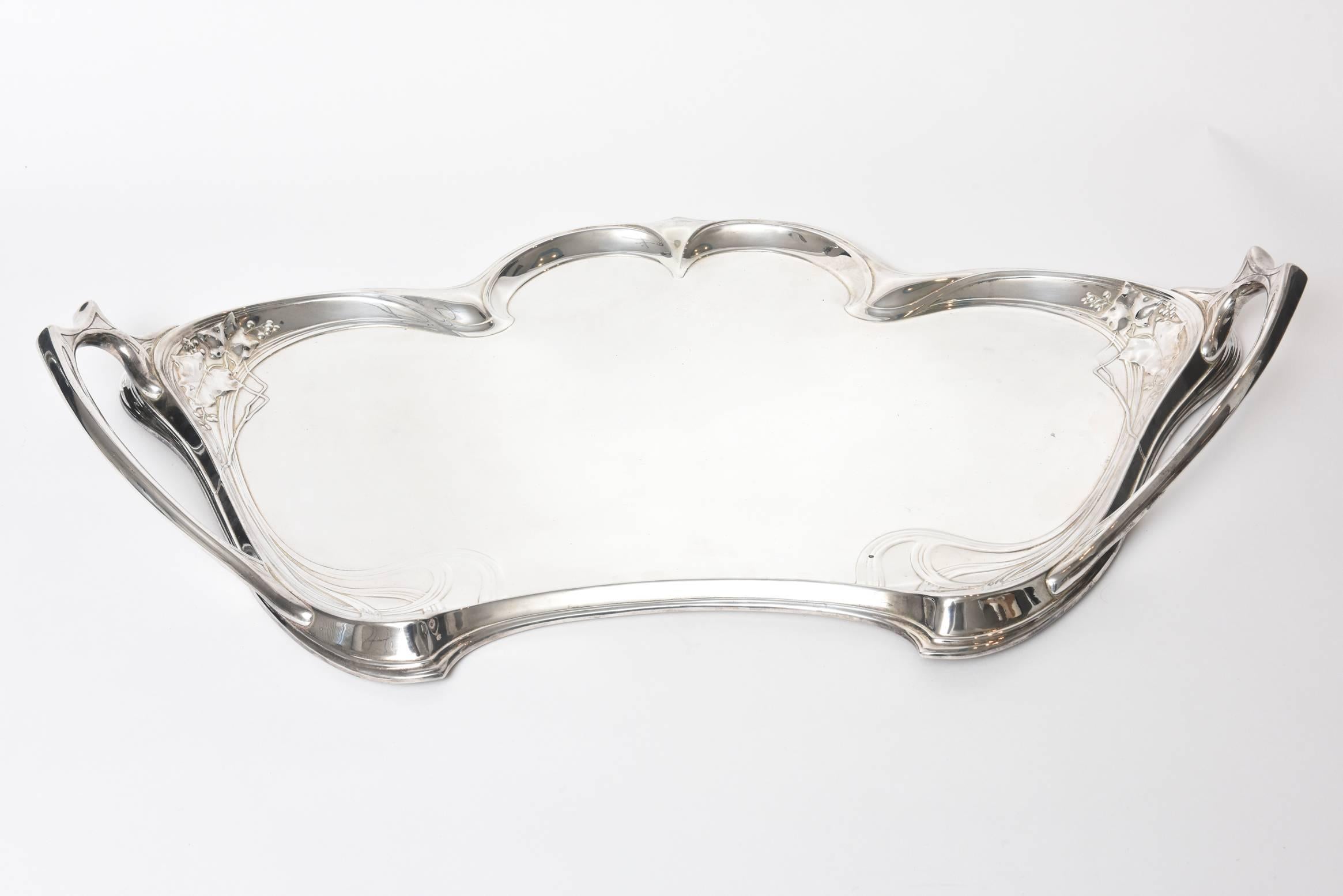 German WMF Art Nouveau silver plated handled waiter's tray with berry and ivy foliage relief with art nouveau patterns and decorative handles. This beautiful tray fits neatly into the waist of the 