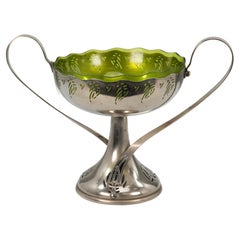 WMF. Centro de mesa Art Nouveau plateado con asas de latigazo y forro de cristal
