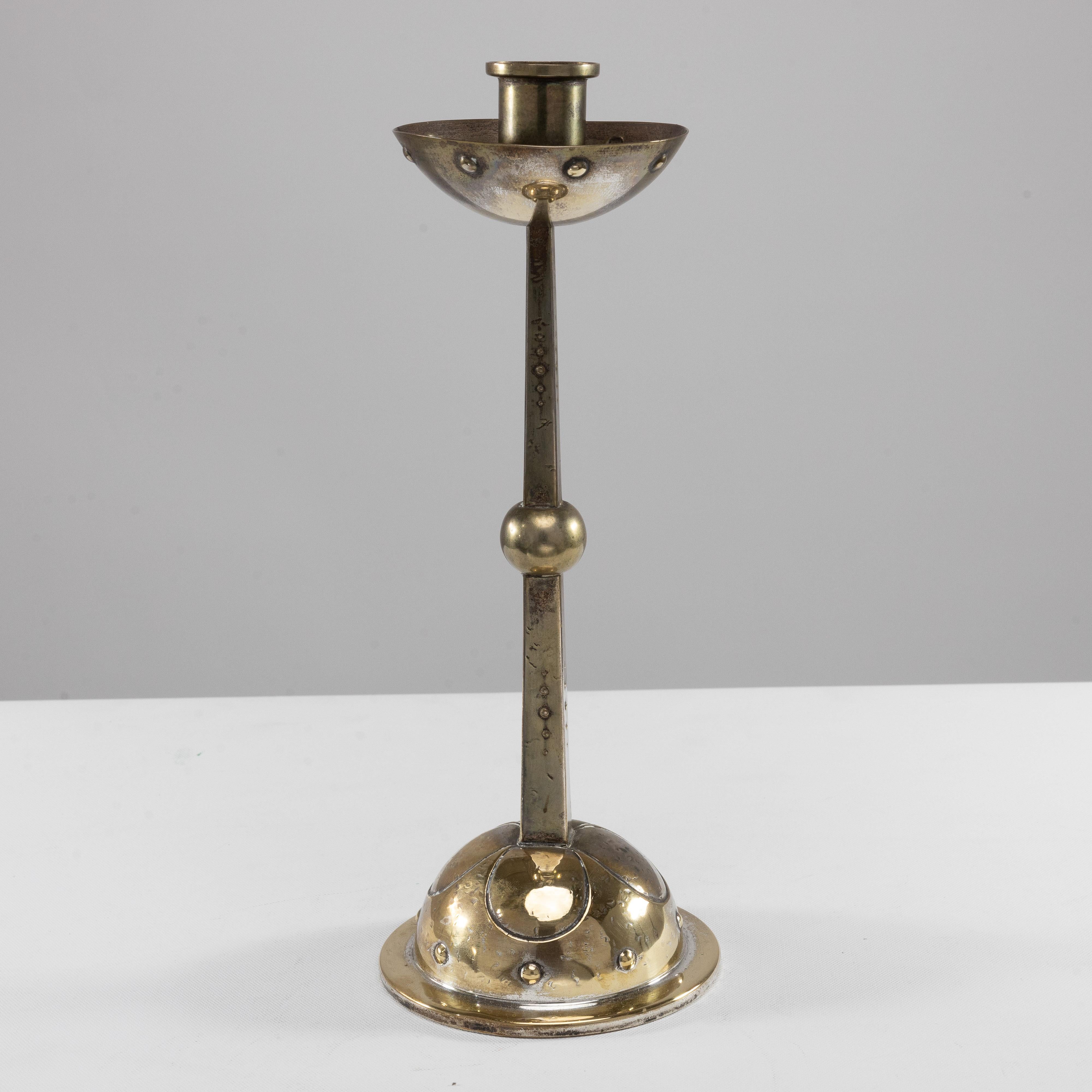 WMF. 
An Arts and Crafts Silver plated candlestick with a bowl-shaped drip tray to the top with dot details, the main stem a central knop also decorated with diminishing dot details uniting to the dome-shaped base.
Stamped to the base WMF and a