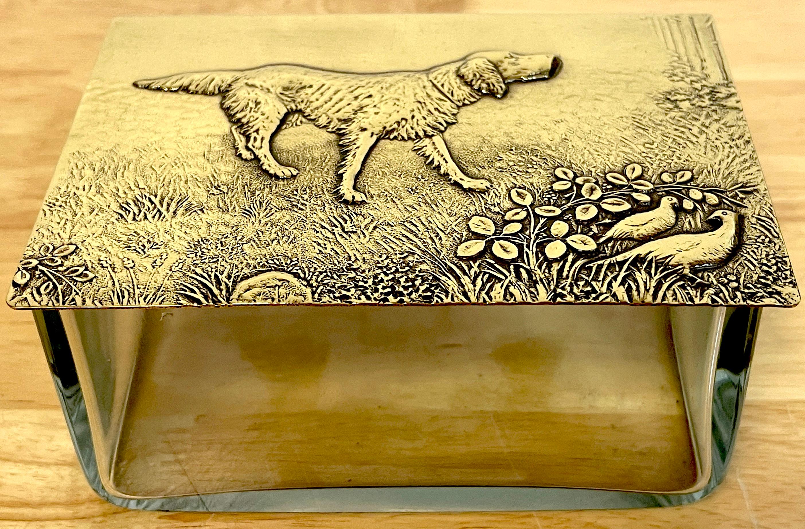 WMF Brass & Crystal Hunting Dog Motif Table Box, 
Germany, circa 1925

Of rectangular form the brass hinged top decorated with chased and engraved decoration of hunting dog in landscape. Resting on a subtle clear cut crystal bottom. Unmarked