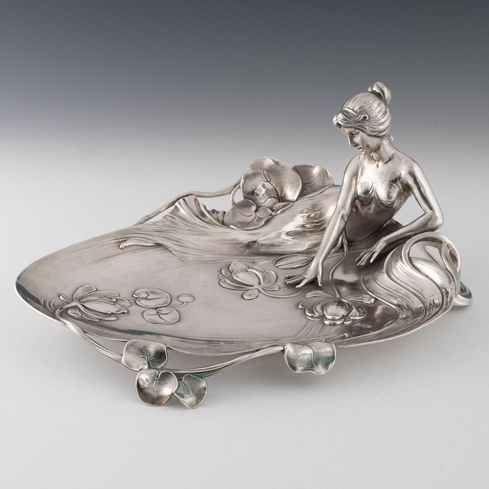 Heading : WMF card tray silver plate depicting a woman

Date : c1905


Origin : Germany

Decoration : Cast depiction of a reclining woman with various flowers and foliage. Stamped 
229 to underside.



Condition :Excellent

Restoration :