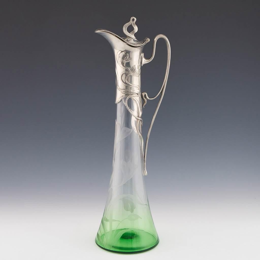 Intestazione : Brocca di chiaretto WMF c1905
Data: c1906
Origine : Geislingen an der Steige
Caratteristiche della ciotola : Ciotola graduata in vetro verde e trasparente con incisione floreale. Manico e coperchio in stile Liberty placcati in