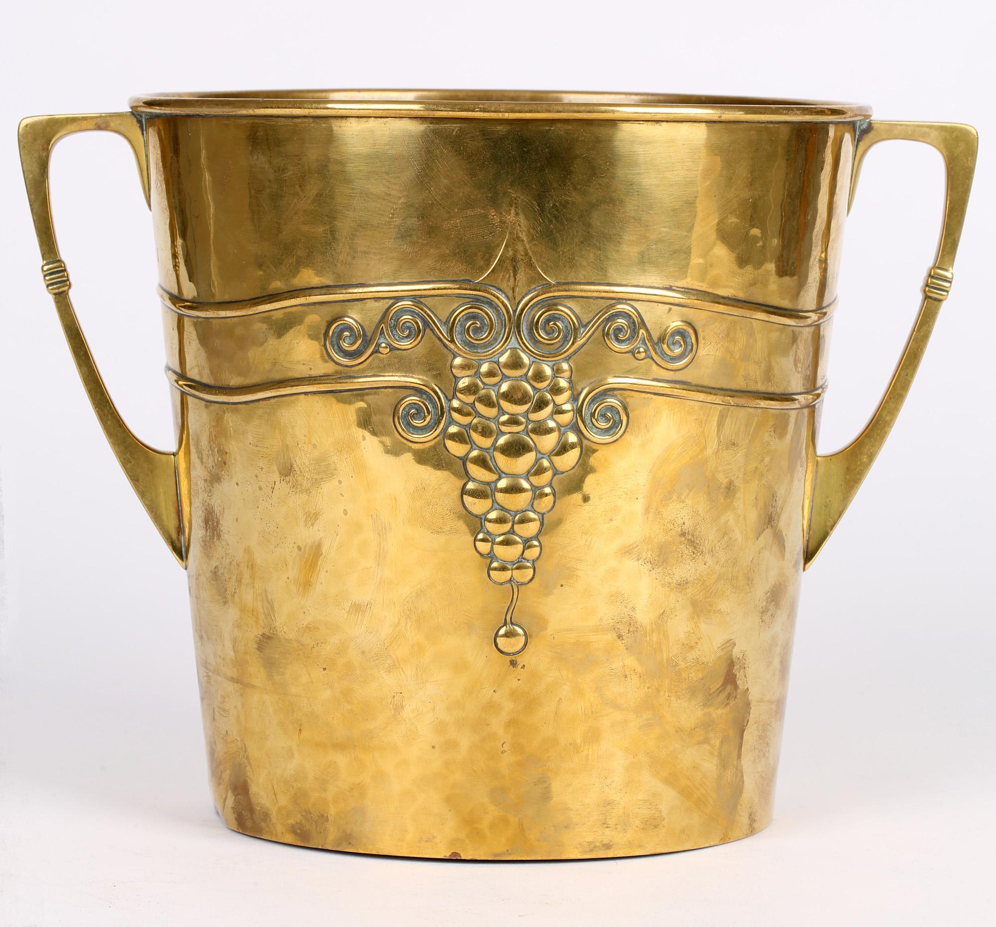 A stylish German Jugendstil (Art Nouveau) brass twin handled ice bucket made by WMF (Württembergische Metallwarenfabrik) and dating from circa 1905. The ice bucket is of wide rounded shape with handles applied to either side and with a hammerec