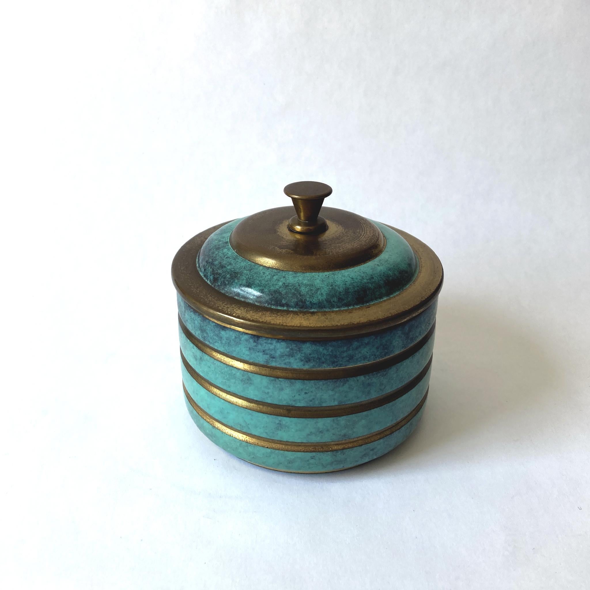 Rare WMF Ikora metal lidded box. The patinated turquoise green metal contrasts beautifully with the gold ringed design. This piece looks wonderful as part of a group, or independently on a dresser or side table. Signed WMF Ikora, see photos. In good