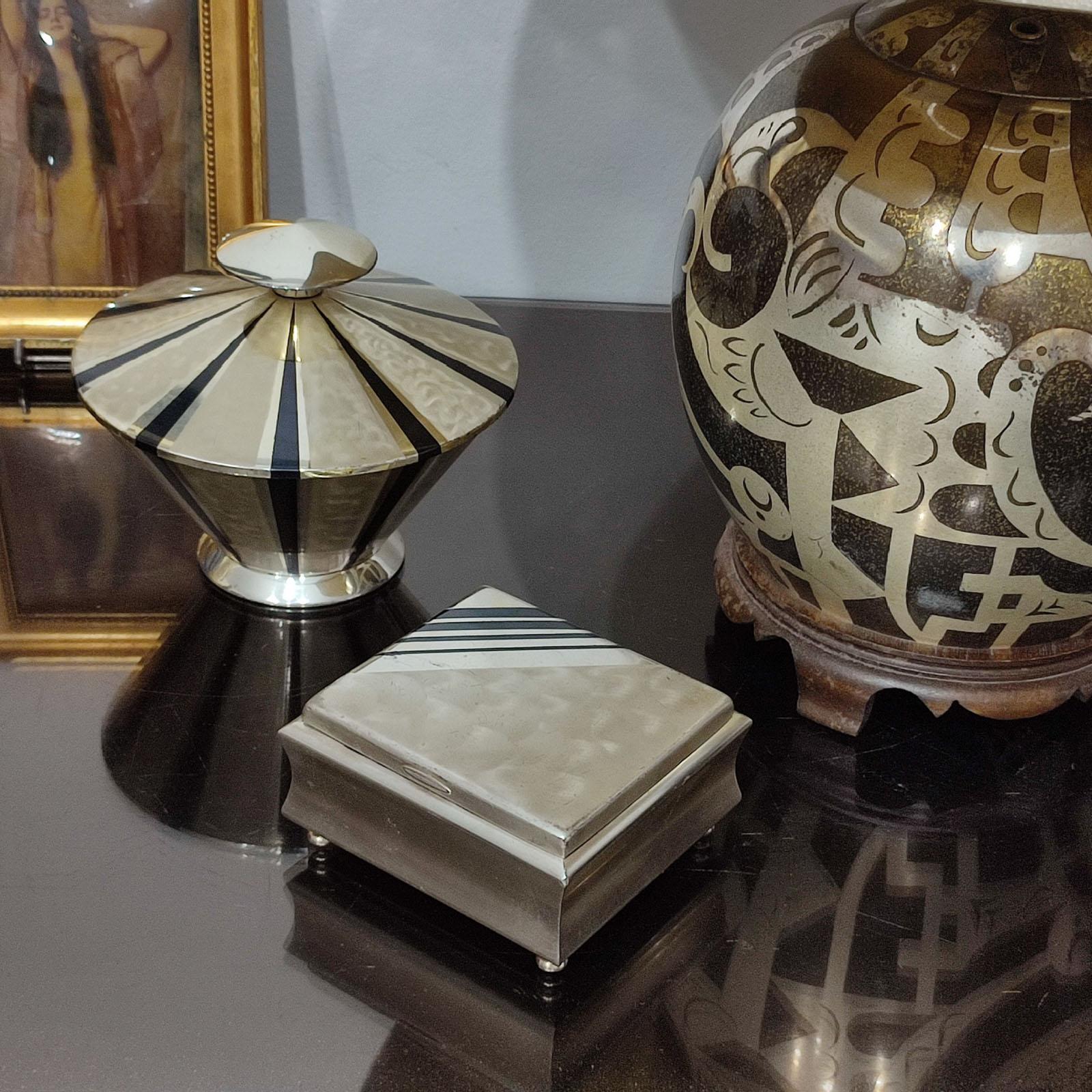 Sophisticated lidded box by WMF for Ikora Metall Collection. Silver-plated Art Deco geometric shape, with a lovely black enamel radial banded motif adorning the top and the body. A perfect piece to store keys or small objects and a lovely addition