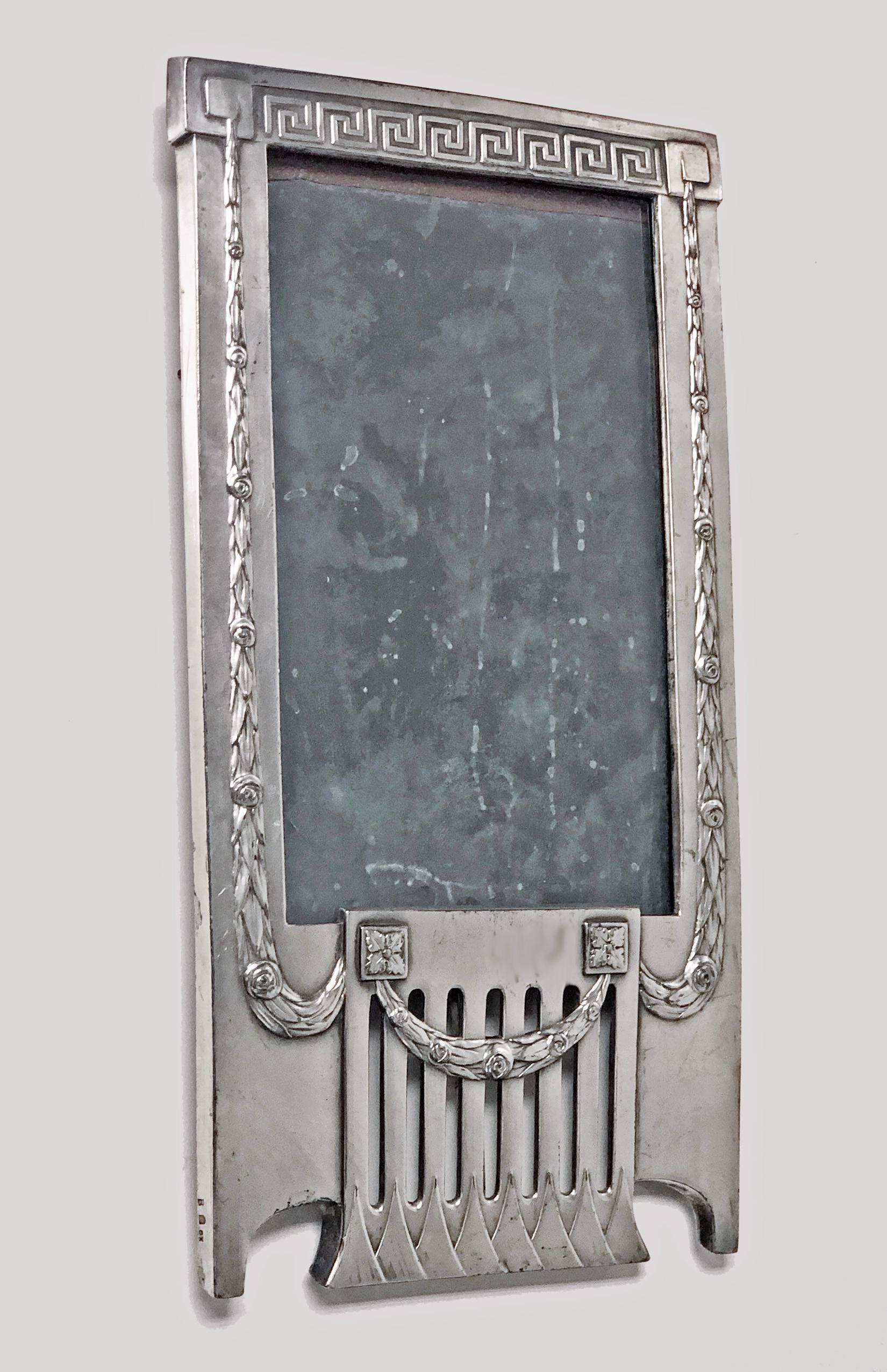 WMF Jugendstil Art Nouveau secessionist photograph frame, Germany, circa 1905. The rare design pewter frame of horizontal rectangular shape with elongated open panel triangular panel lower frieze, the surround of frame festoon wreath and Greek key