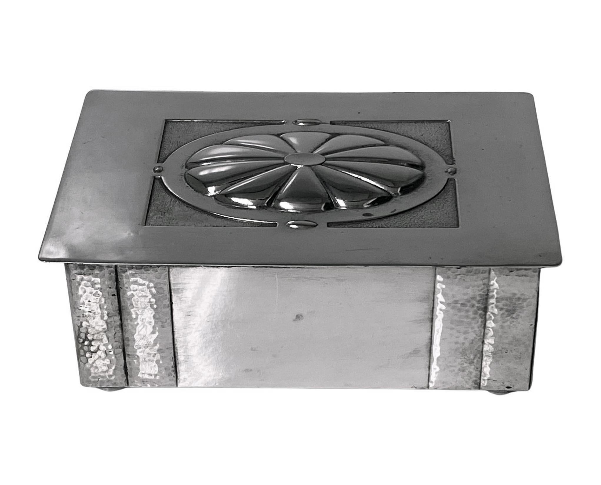 WMF Jugendstil silver plate Cigarette or Jewellery Box C.1920. The box on four bun feet, rectangular in shape; the cover with oval central slightly raised lobate panel with stippled background. The sides plain with hammered finish double panel