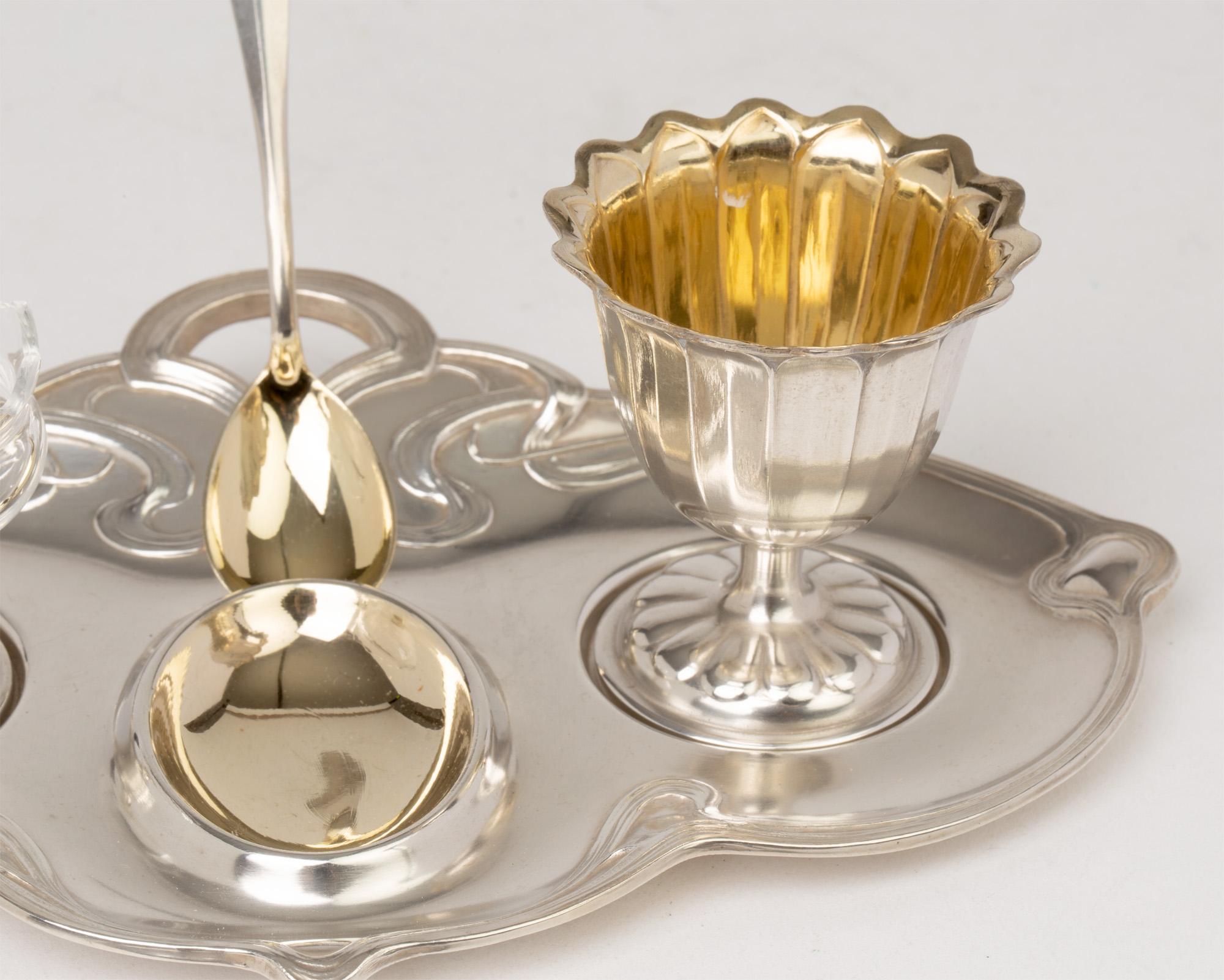 An exceptional quality WMF (Württembergische Metallwarenfabrik) German Jugendstil silver plated egg cup stand with salt and original spoon dating from circa 1900. The set comprises of a small handled tray with moulded interlaced scrolling around the