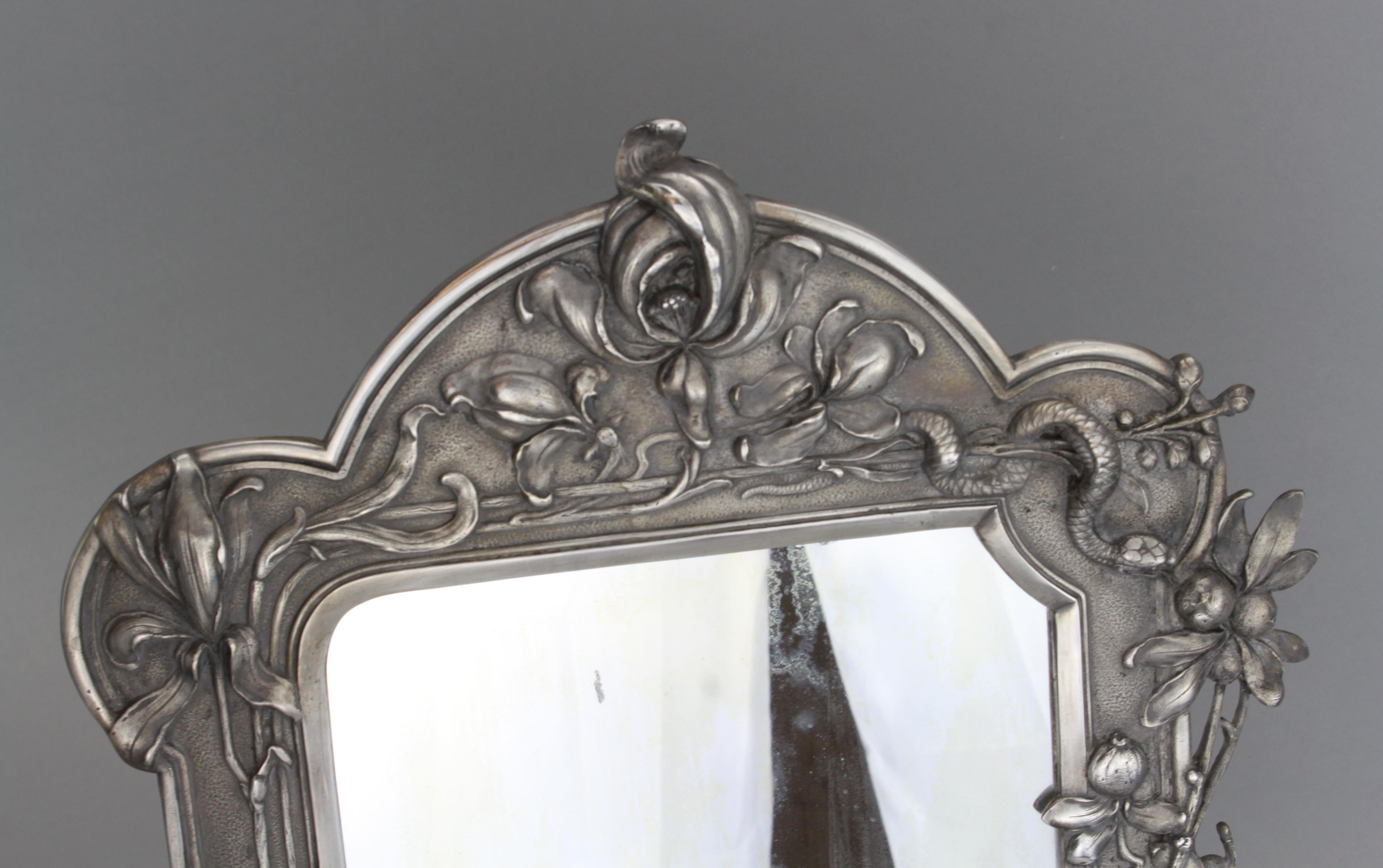 An Art Nouveau silver plated dressing table mirror
The shaped frame decorated with fish, dragonfly, snake and irises.

Made by WMF 