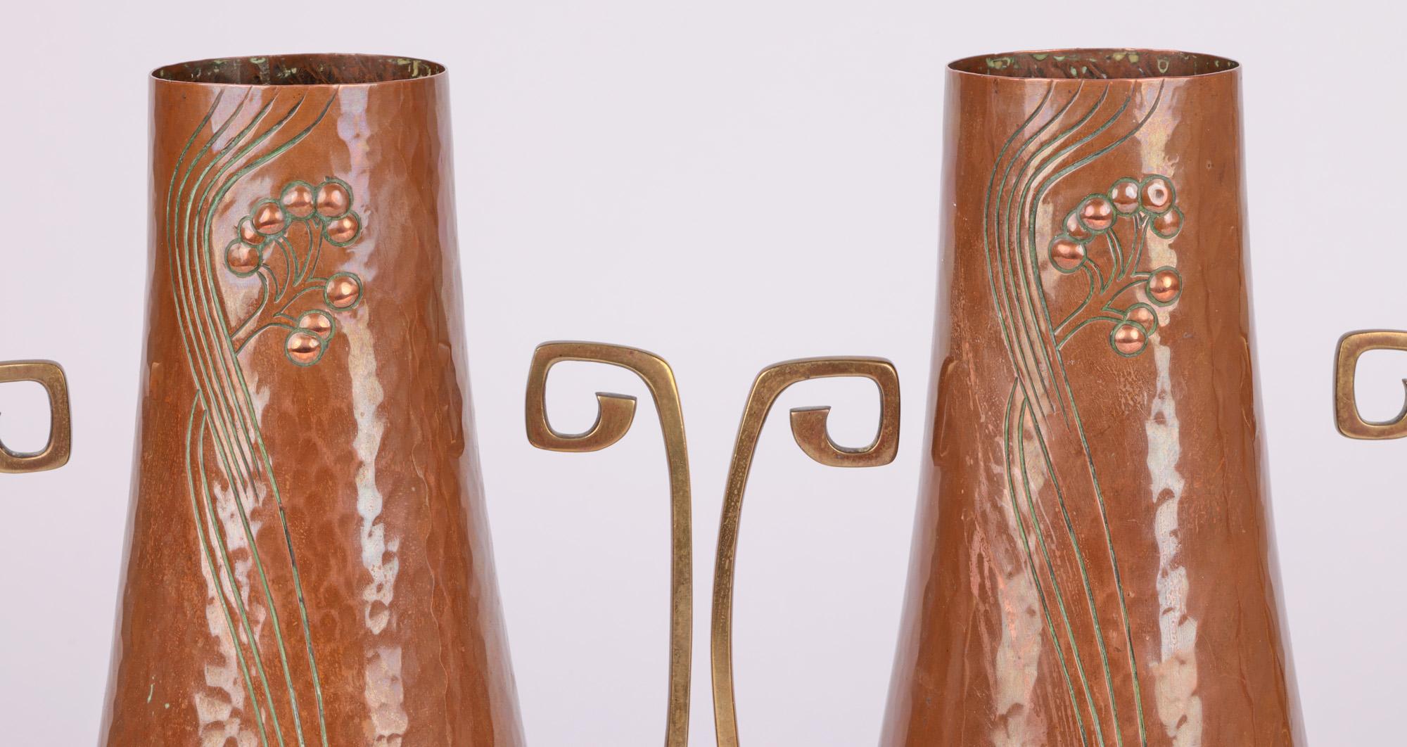 A very stylish Jugendstil pair German copper and brass vases by renowned makers WMF (Württembergische Metallwarenfabrik) and dating from around 1900. The tall and elegantly shaped vases have copper bodies standing raised on narrow pinched bases with