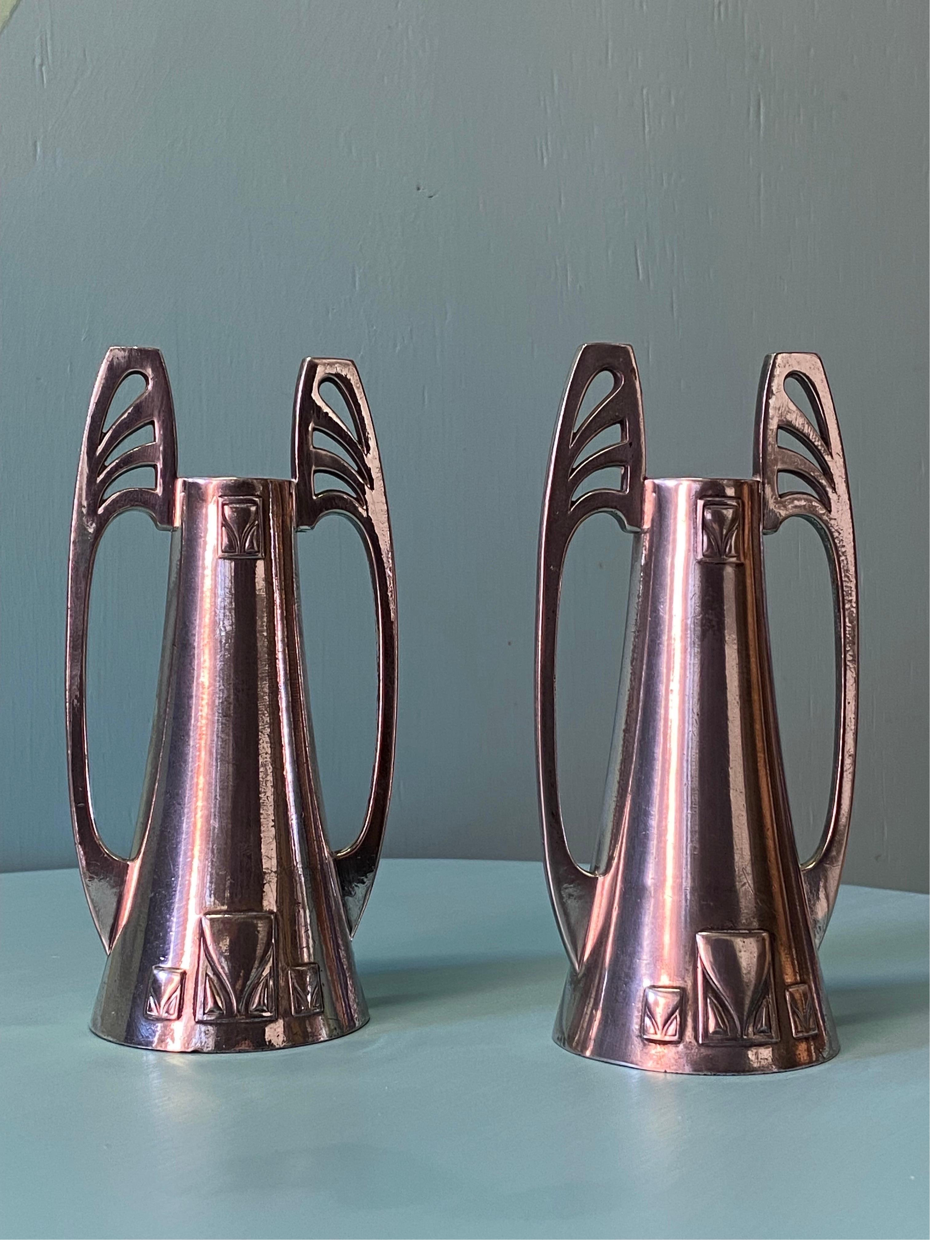 A pair of Art Nouveau or Secessionist WMF 'Britannia metal' (pewter) and silver plate candle holders. Both marked to the interior of the base 'WMFB' and 'OX'. This finish was used between 1900 and 1912 and was a thick silver plate with an oxidized