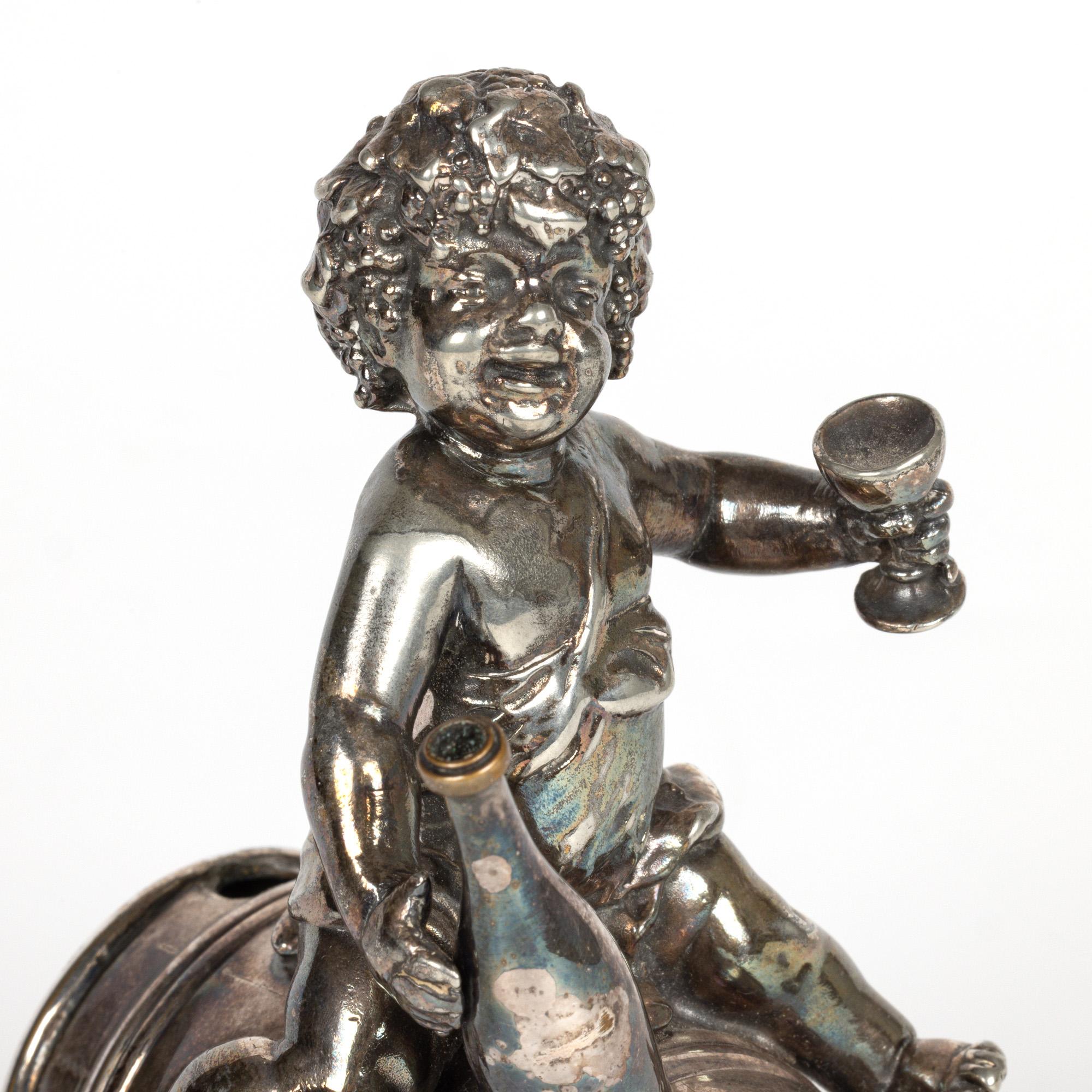 Un elegante versatore di gin figurato in stile Jugendstil tedesco, realizzato dai rinomati produttori WMF (Württembergische Metallwarenfabrik) e risalente al 1900 circa. Il versatore di gin è montato su un barile sollevato su quattro piedi a voluta